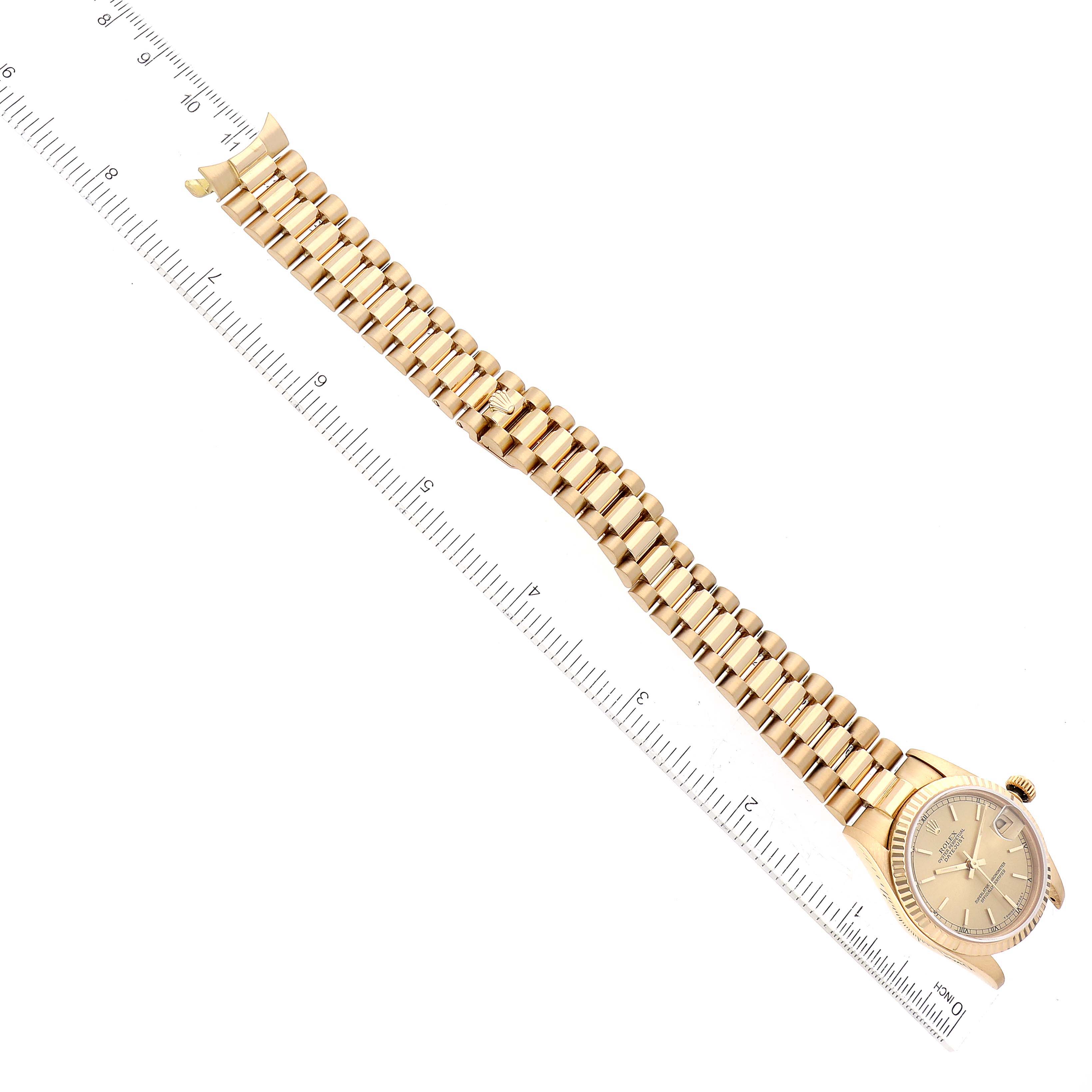 The image shows a top-down view of a Rolex President 68278 Women
s Yellow Gold Champagne Dial 68278 Women
s Yellow Gold Champagne Dial model watch with a ruler placed alongside for measurement.