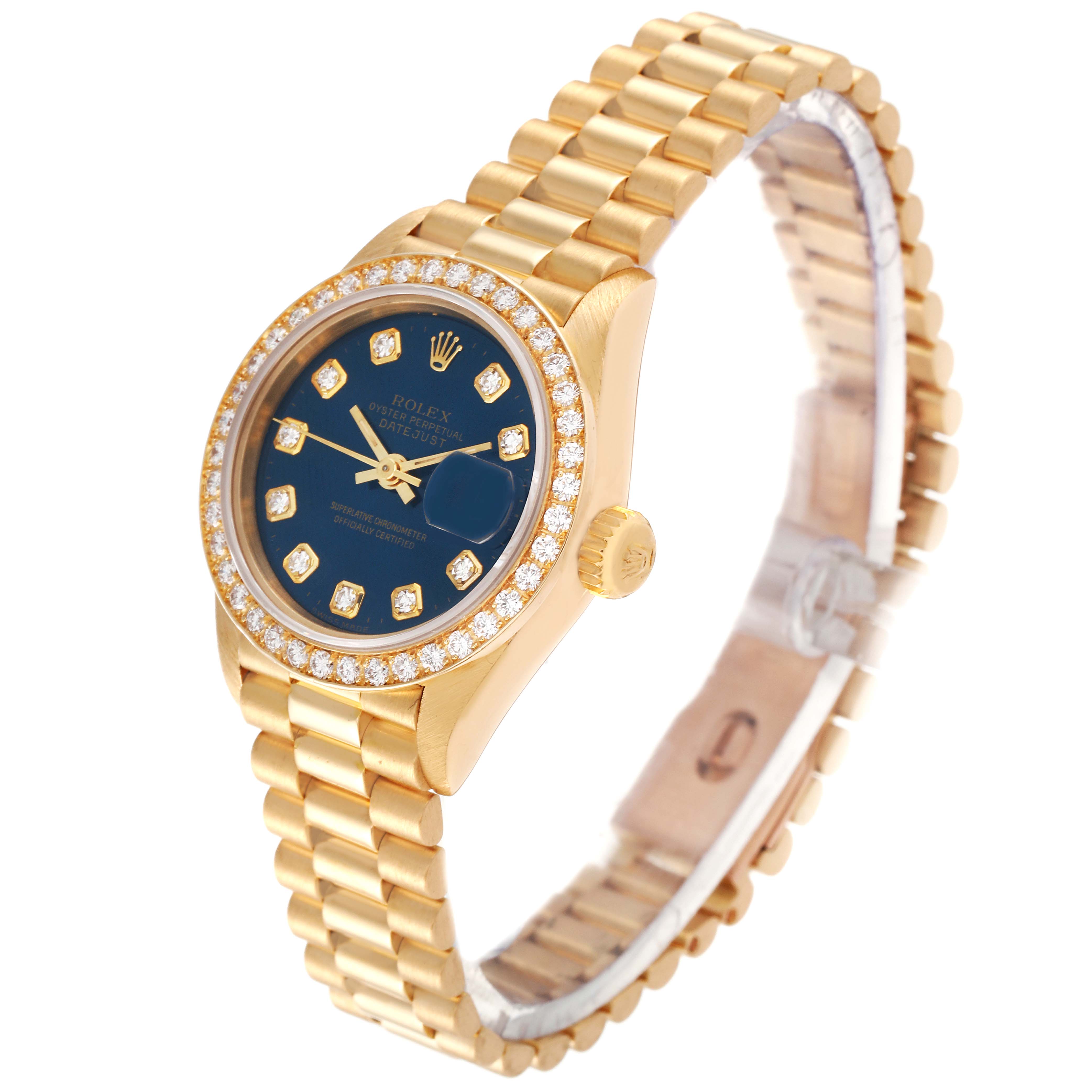 The image shows a Rolex President 69138 Women's Yellow Gold Blue Dial 69138 Women's Yellow Gold Blue Dial model watch in a three-quarter angle featuring its gold bracelet and diamond-set bezel.