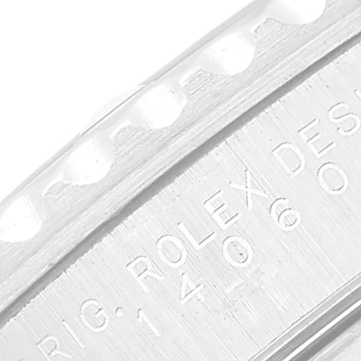 The image shows a close-up of the engraved hull and bezel of a Submariner model by Rolex.