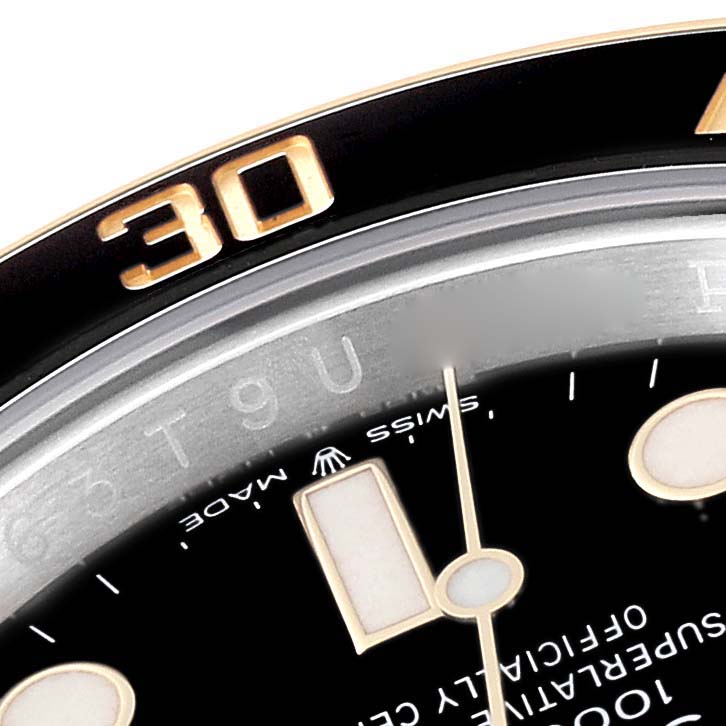 The image shows a close-up of the bezel, dial, and part of the hour hand of a Rolex Submariner M126613LN-0002 Men's Steel and Gold (two tone) Black Dial M126613LN-0002 Men's Steel and Gold (two tone) Black Dial watch.
