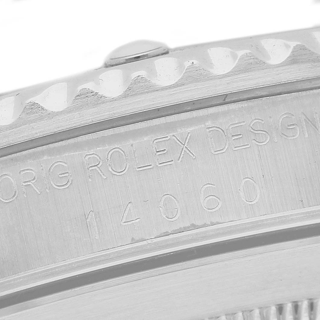 The close-up image shows the engraved side of the bezel and case of a Rolex Submariner 14060 Men's Stainless Steel Black Dial, revealing part of its design details.