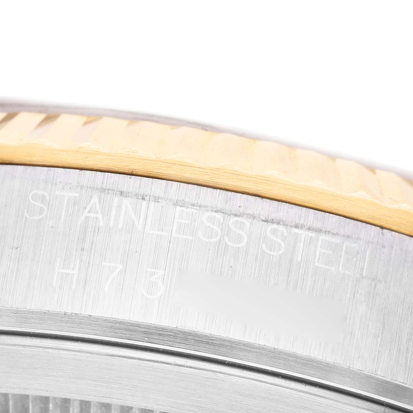 The image shows a close-up of the bezel and edge of the case back, highlighting the engraving on the Tudor Prince M76213 Men's Steel and Gold (two tone) Black Dial watch.