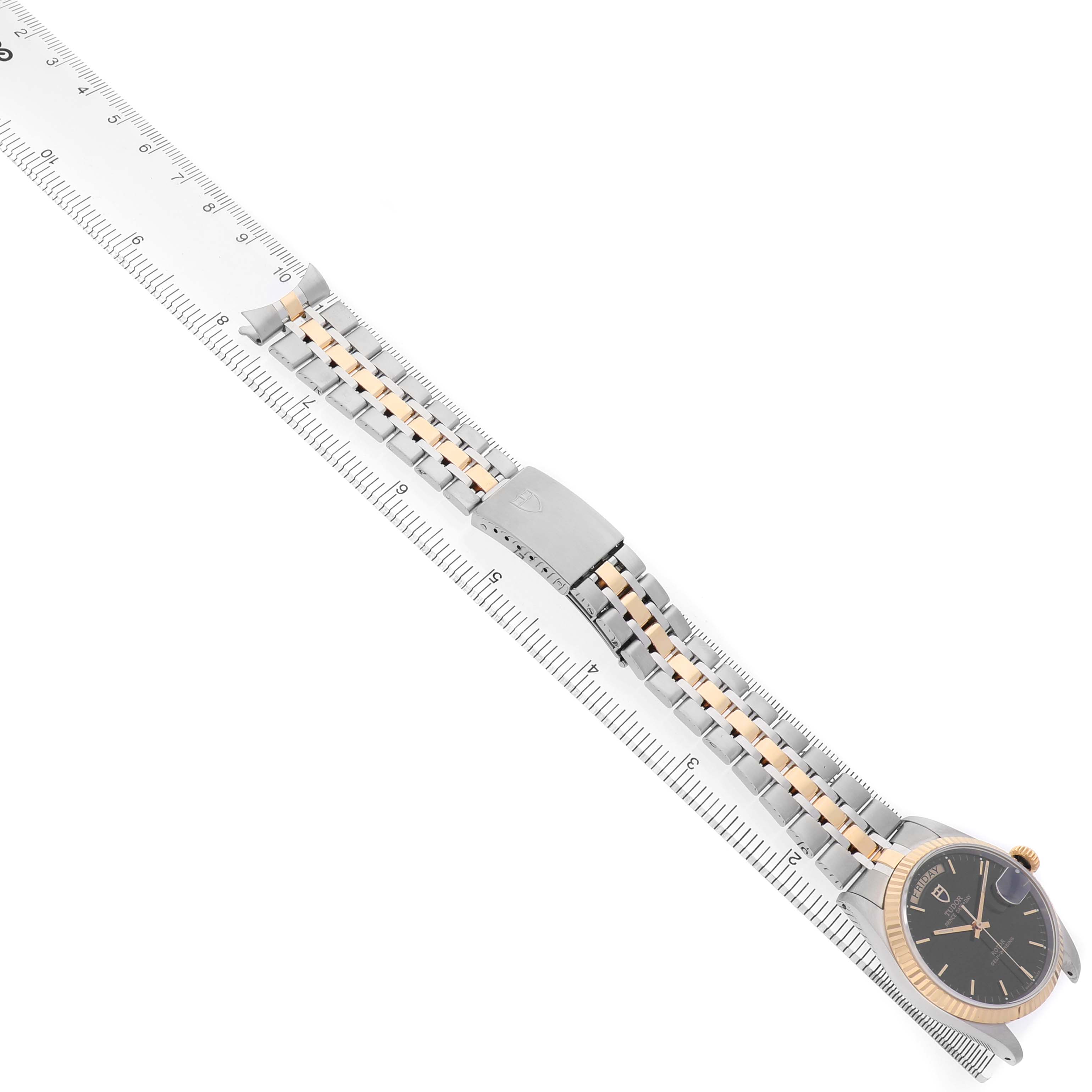 The image shows a Tudor Prince M76213 Men's Steel and Gold (two tone) Black Dial watch at a side angle, highlighting the bracelet and clasp along a ruler for measurement.