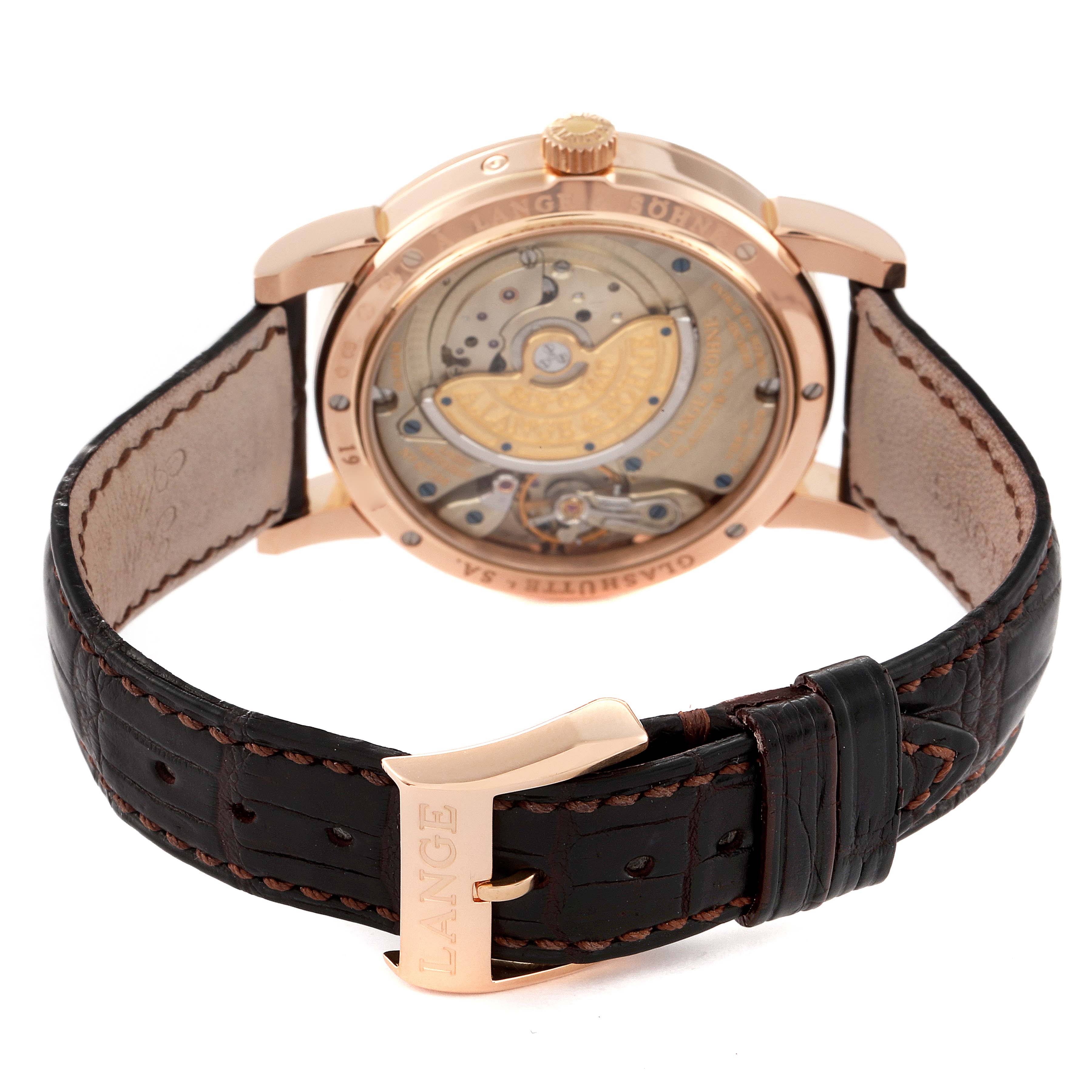 This image shows the back of the A. Lange & Sohne Saxonia 330.032 Men's Rose Gold Silver Dial model, highlighting its movement through a transparent case and the leather strap.