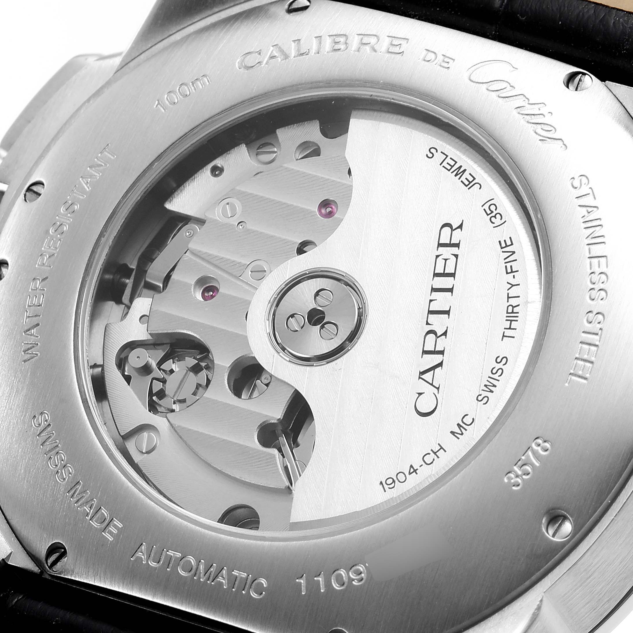 The image shows the back view of a Calibre de Cartier watch by Cartier, highlighting its automatic movement and engravings.