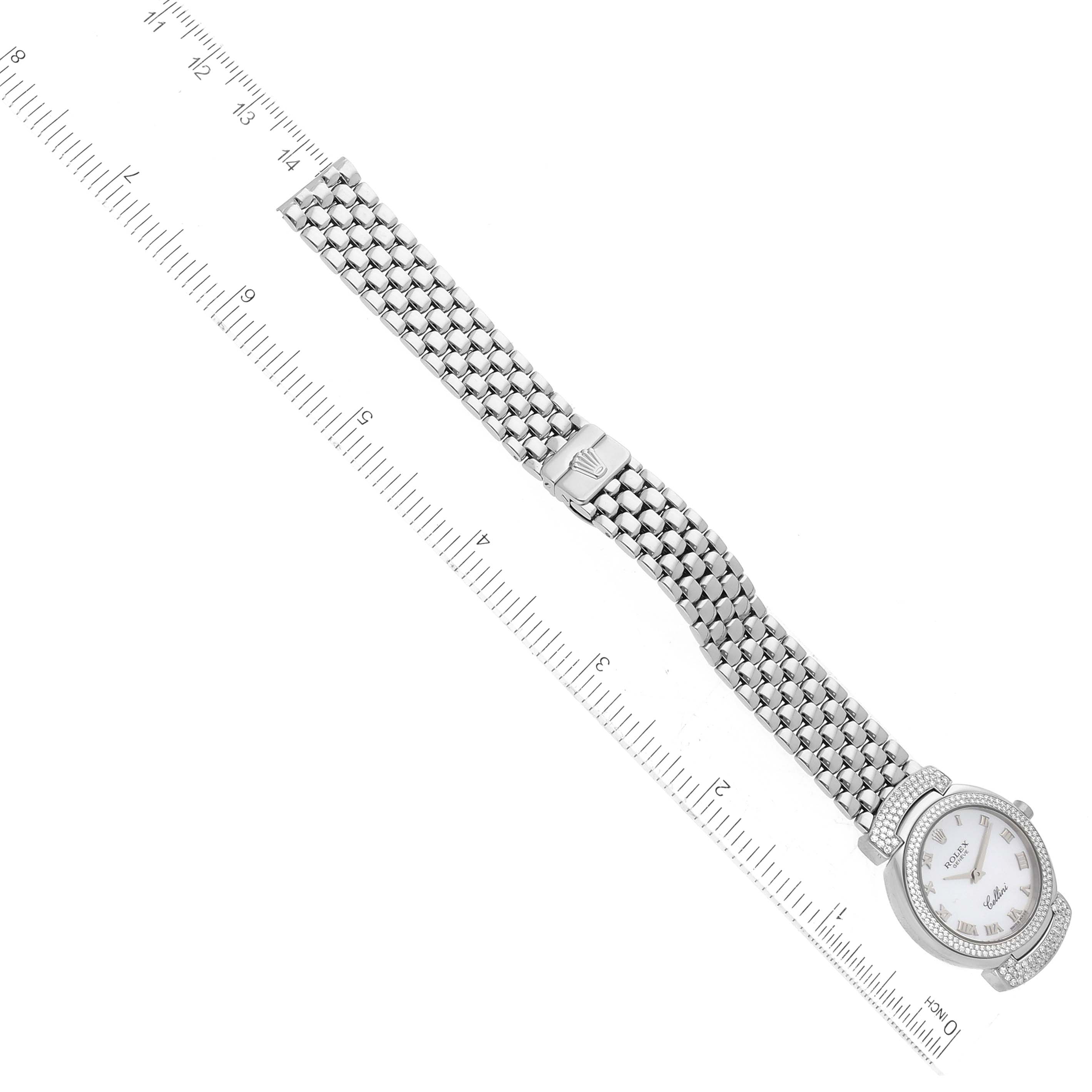 The image shows a top-down view of a Rolex Cellini 6673 Women's White Gold Mother of Pearl Dial 6673 Women's White Gold Mother of Pearl Dial watch, displaying its face, bracelet, and clasp, accompanied by a ruler for scale.