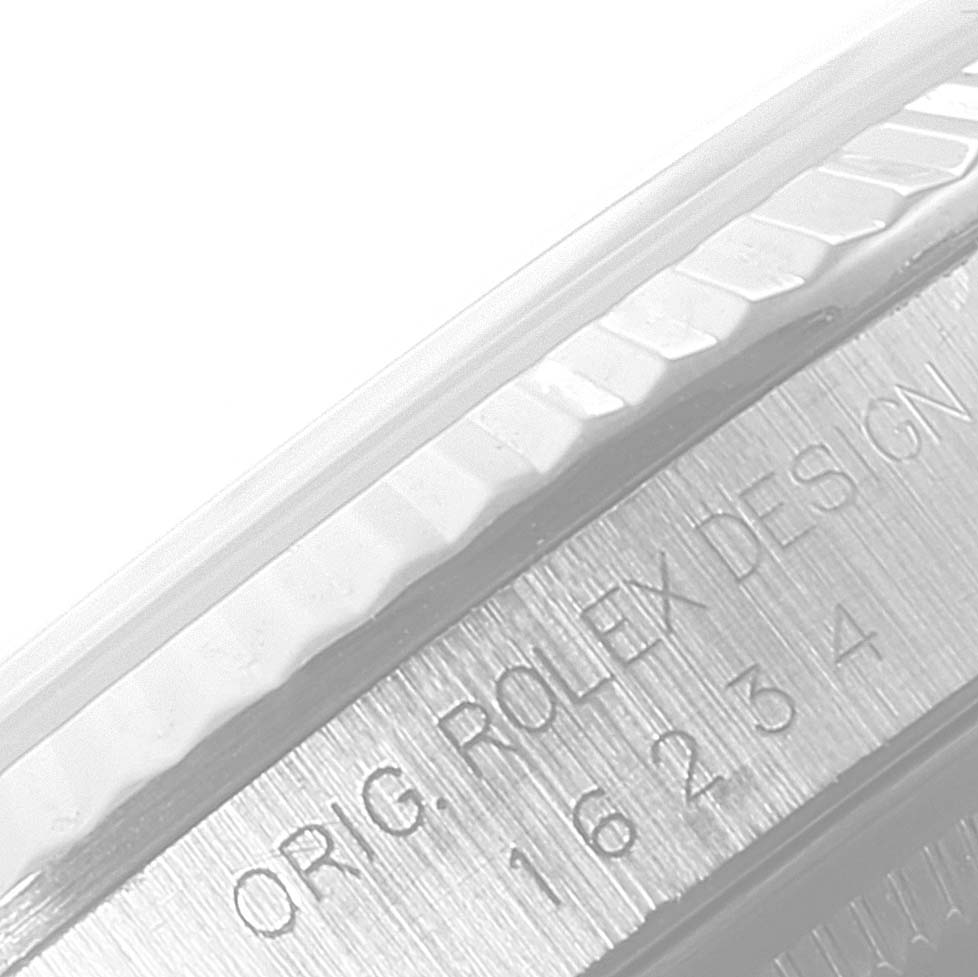 The image shows a close-up angle of the bezel and the engraved side of the case of a Rolex Datejust 16234 Men's Stainless Steel Blue Dial 16234 Men's Stainless Steel Blue Dial watch.