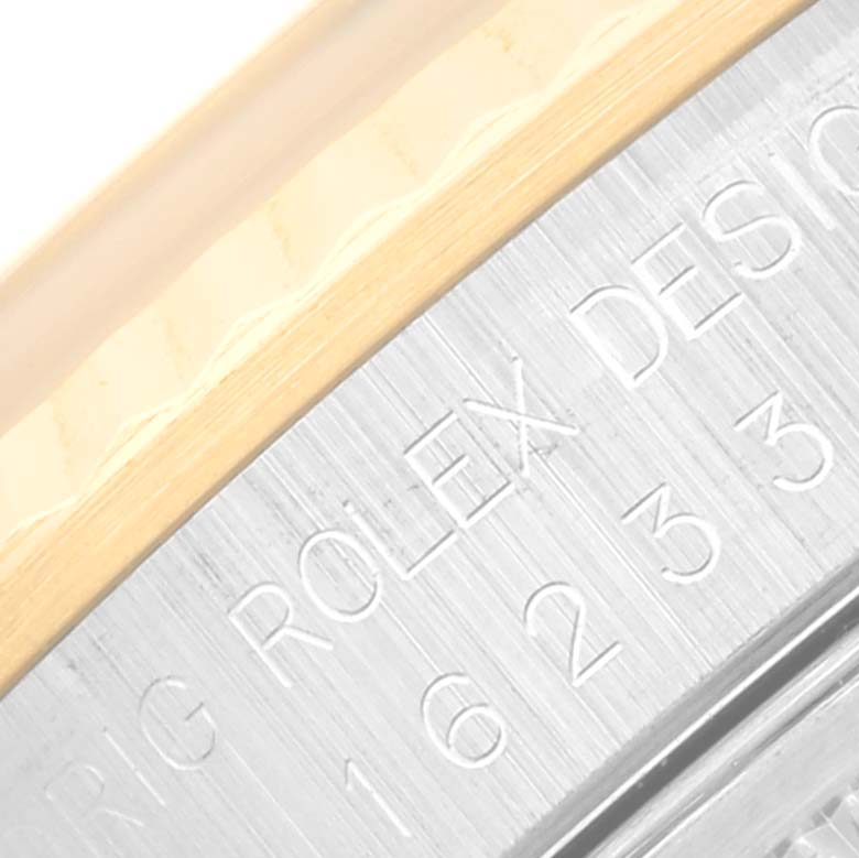 The image shows a close-up of the engraved bezel and case edge of a Rolex Datejust 16233 Men's Steel and Gold (two tone) Champagne Dial 16233 Men's Steel and Gold (two tone) Champagne Dial watch.