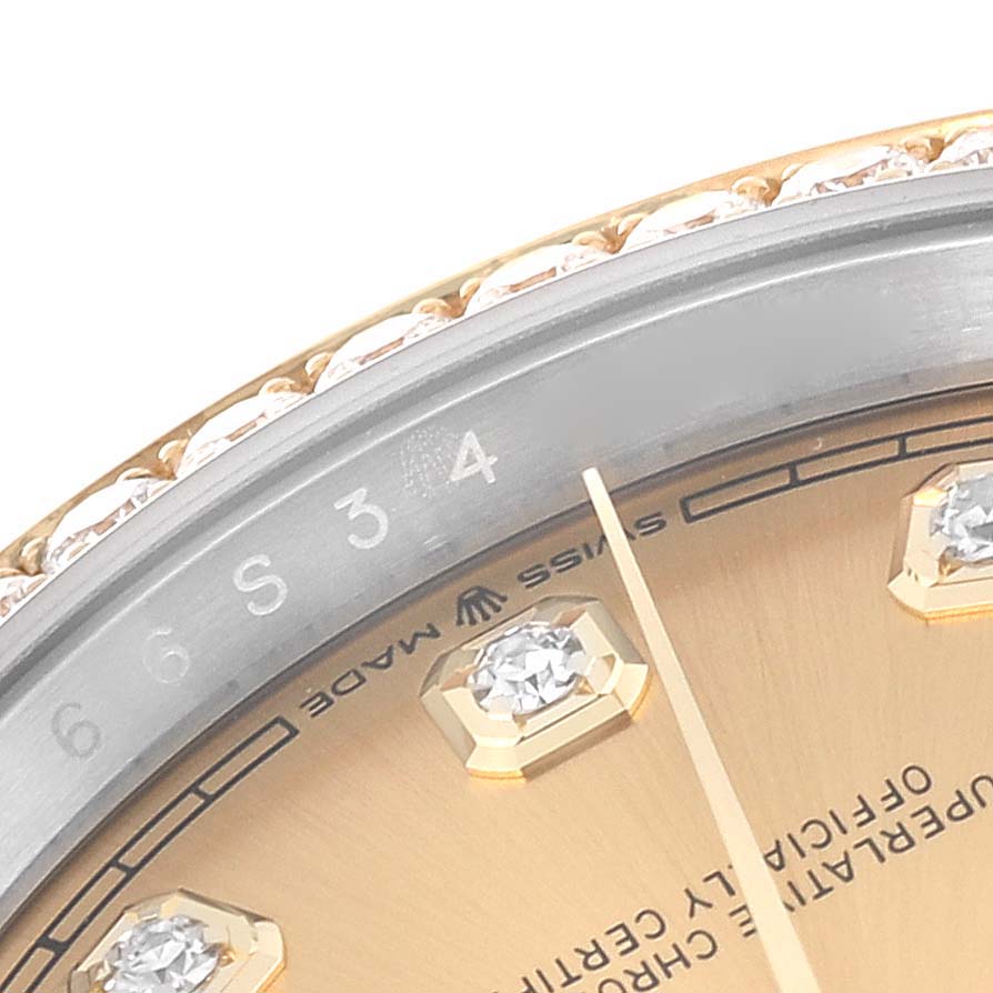 The image shows a close-up of the face and bezel of a Rolex Datejust M126283RBR-0003 Men's Steel and Gold (two tone) Champagne Dial M126283RBR-0003 Men's Steel and Gold (two tone) Champagne Dial watch, highlighting the markings and gem details.