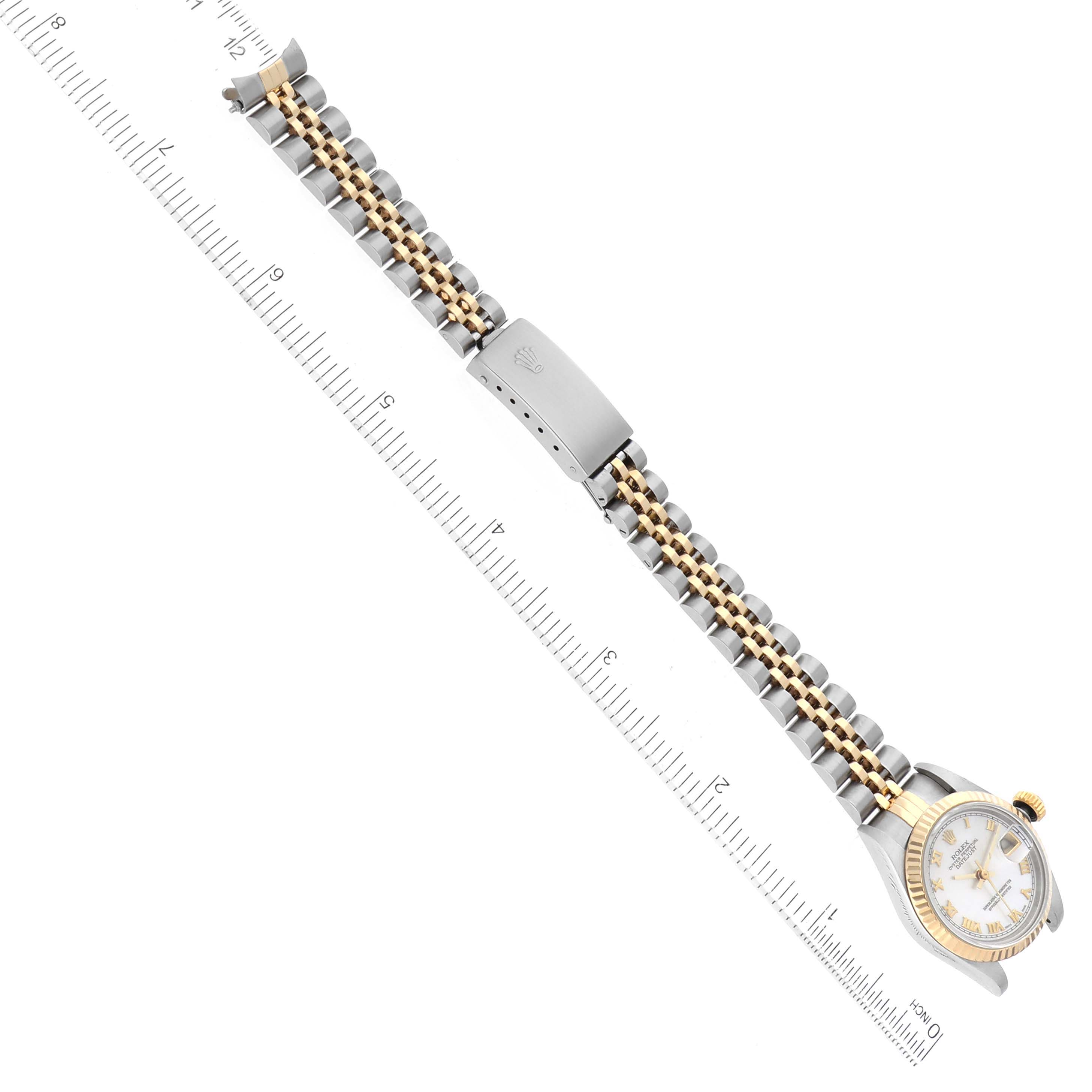 This image shows a Rolex Datejust 69173 Women's Steel and Gold (two tone) Mother of Pearl Dial 69173 Women's Steel and Gold (two tone) Mother of Pearl Dial watch viewed from above, featuring its bracelet and clasp laid out flat against a ruler.