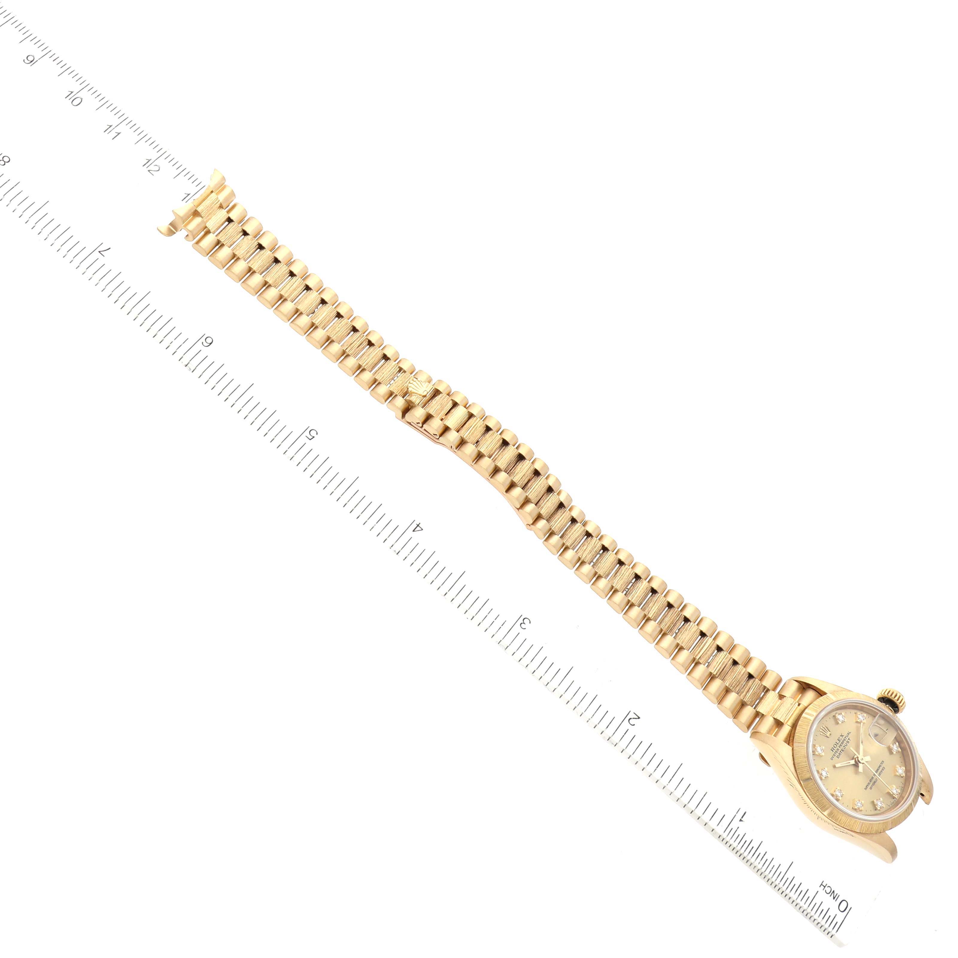 The image shows a Rolex President 69278 Women
s Yellow Gold Champagne Dial 69278 Women
s Yellow Gold Champagne Dial model watch laid out with a bracelet and a ruler for size reference.