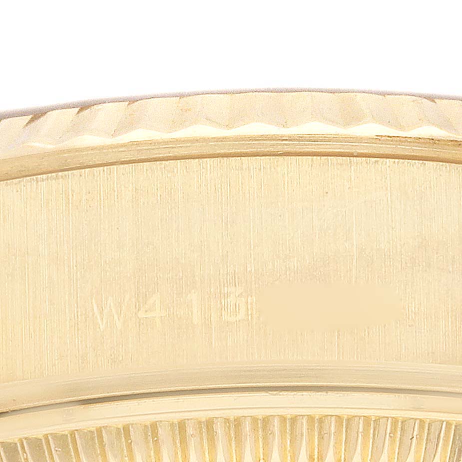 Close-up view of the Rolex President 69178 Women
s Yellow Gold Champagne Dial 69178 Women
s Yellow Gold Champagne Dial model, showing the fluted bezel and part of the engraved serial number.