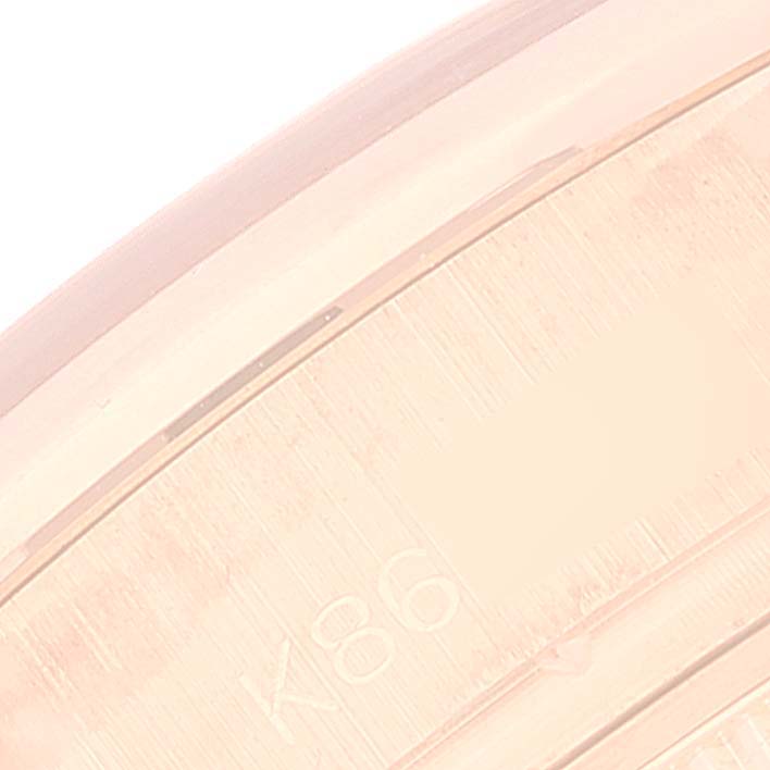This image shows a close-up of a small section of the case of a Rolex President 179165 Women's Rose Gold White Dial 179165 Women's Rose Gold White Dial model watch, highlighting the etched markings.