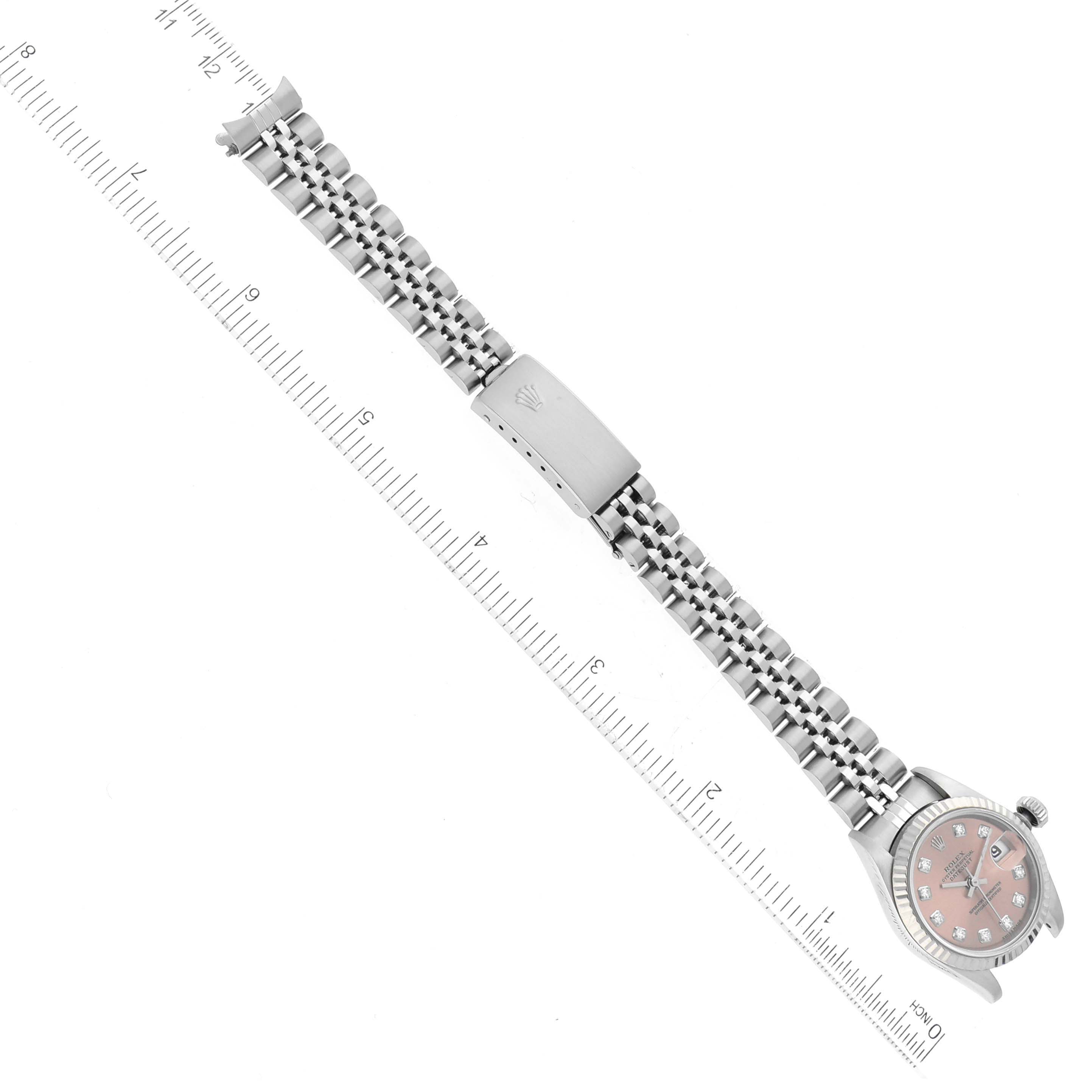 The Rolex Datejust 79174 Women's Stainless Steel Pink Dial 79174 Women's Stainless Steel Pink Dial watch is shown flat with its full metal bracelet extended beside a ruler for size reference.