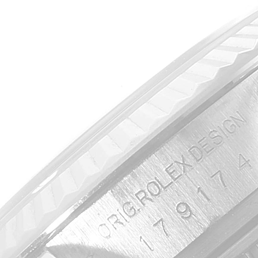 The image shows a close-up of the engraved side of a Rolex Datejust 179174 Women's Stainless Steel Black Dial 179174 Women's Stainless Steel Black Dial watch, displaying part of the bezel and serial number.