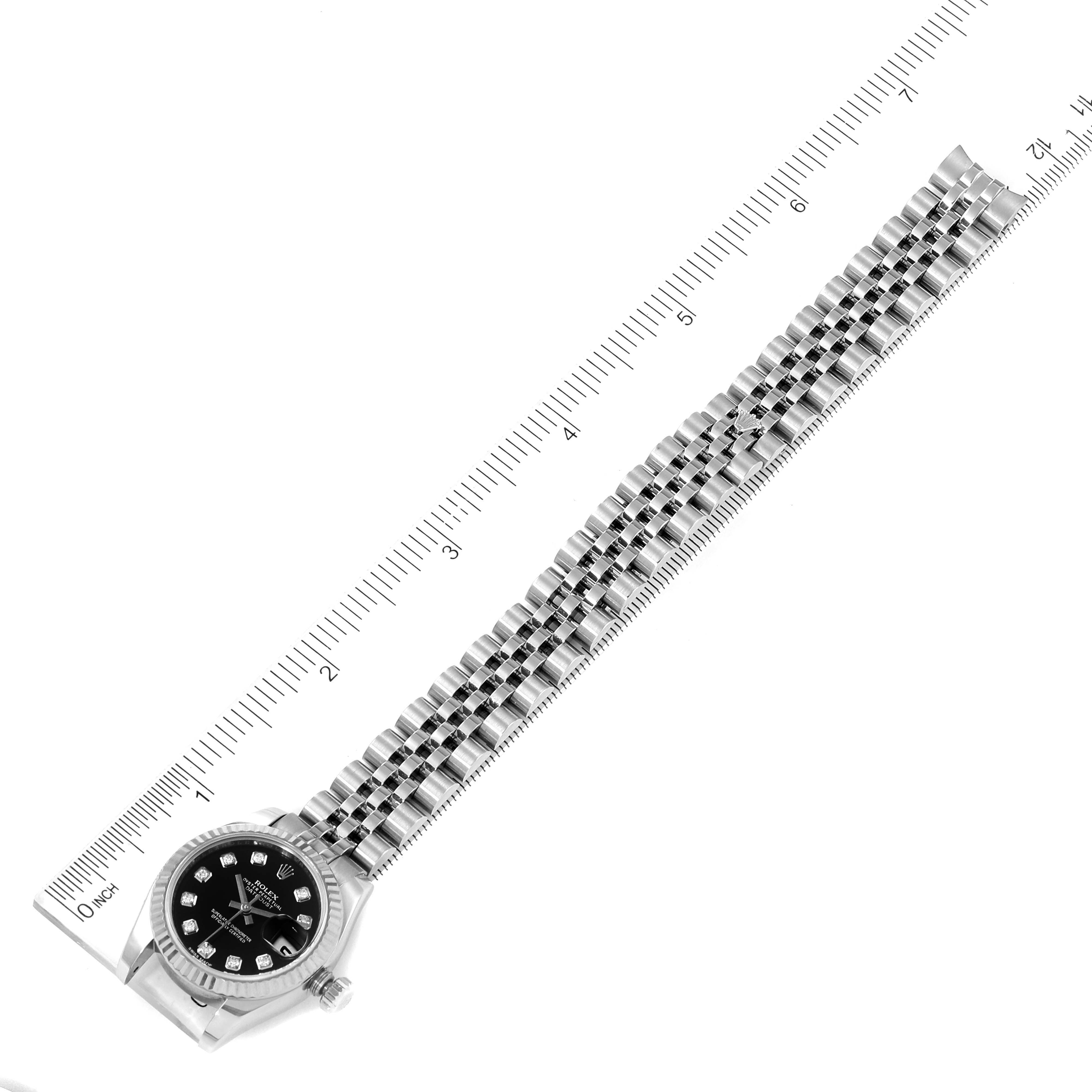 The image shows a Rolex Datejust 179174 Women's Stainless Steel Black Dial 179174 Women's Stainless Steel Black Dial watch laid flat with its face and bracelet fully visible against a ruler for scale.