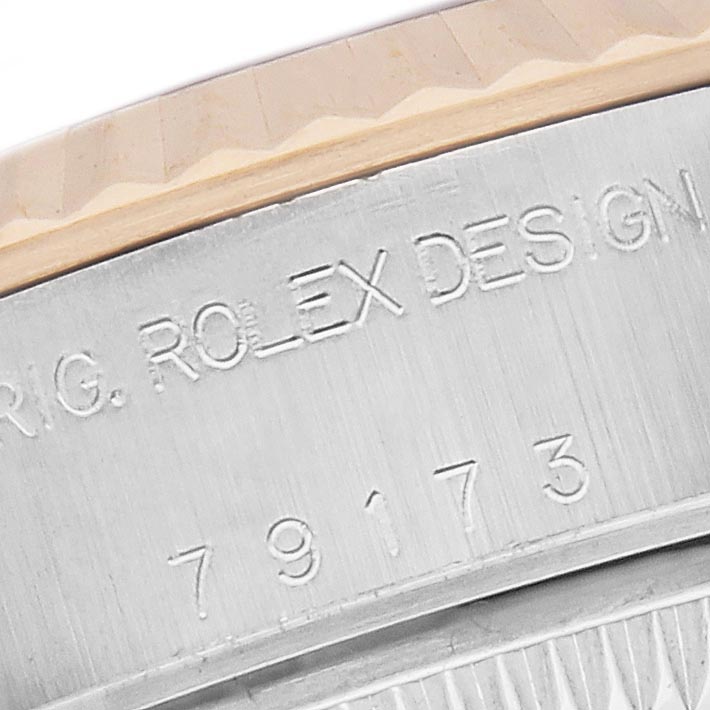 The image shows a close-up of the side of the Rolex Datejust 79173 Women's Steel and Gold (two tone) Champagne Dial 79173 Women's Steel and Gold (two tone) Champagne Dial case, featuring engraved text and the model number.