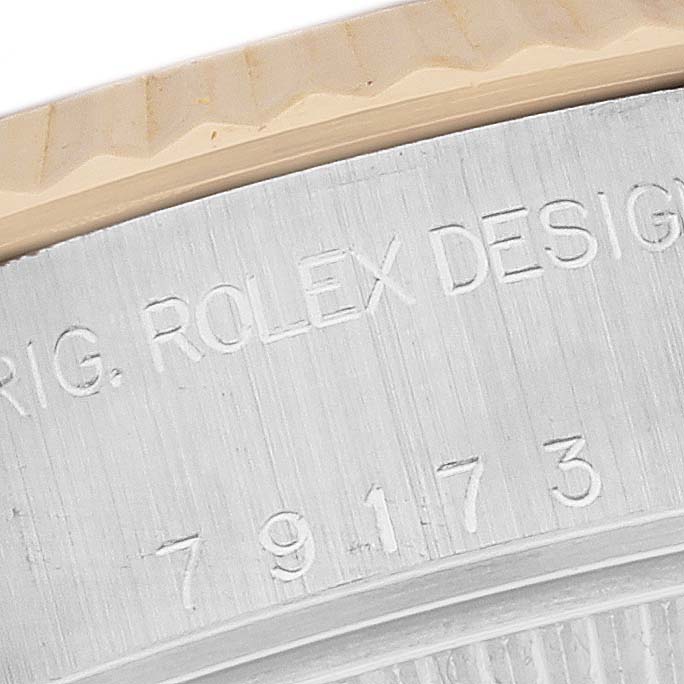 The close-up image shows the engraved markings on the side of a Rolex Datejust 79173 Women's Steel and Gold (two tone) Silver Dial 79173 Women's Steel and Gold (two tone) Silver Dial watch case.