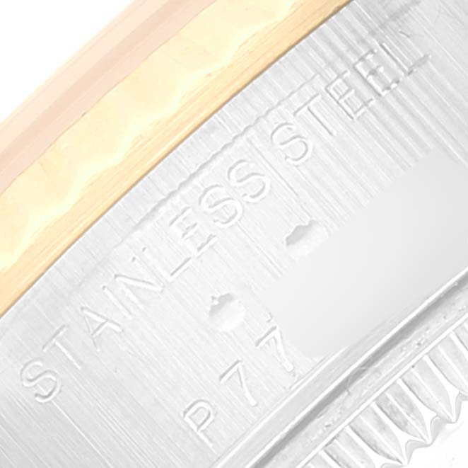 The image shows a close-up of the edge of a Rolex Datejust 79173 Women's Steel and Gold (two tone) Grey Dial 79173 Women's Steel and Gold (two tone) Grey Dial watch, highlighting the stainless steel part and partial inscription.