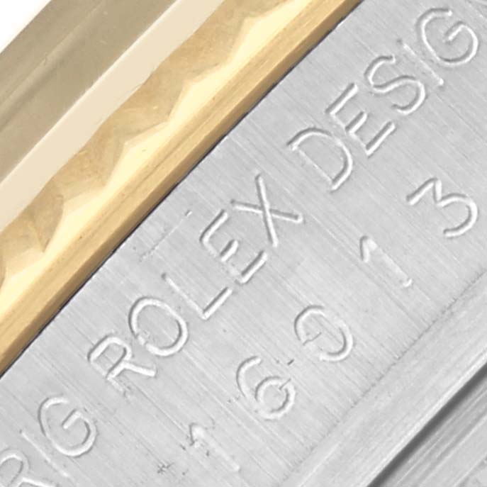 The image shows a close-up of the Rolex Datejust 16013 Men's Steel and Gold (two tone) Champagne Dial 16013 Men's Steel and Gold (two tone) Champagne Dial case side with an engraved design number and part of the fluted bezel.