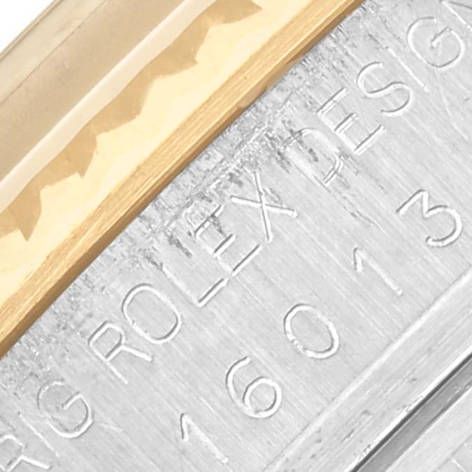 The image shows a close-up of the side of a Rolex Datejust 16013 Men's Steel and Gold (two tone) Champagne Dial 16013 Men's Steel and Gold (two tone) Champagne Dial, focusing on the engraved model number and part of the bezel.