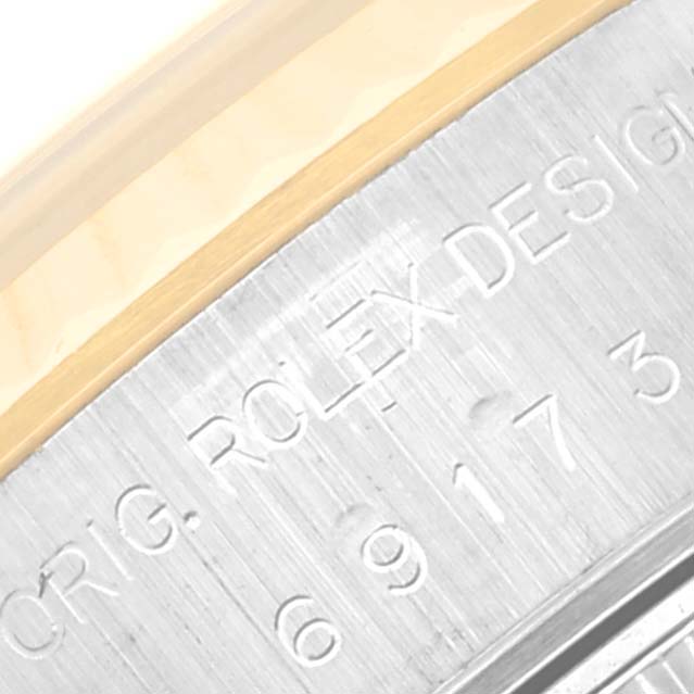 This close-up image shows the engraved side of a Rolex Datejust 69173 Women's Steel and Gold (two tone) White Dial 69173 Women's Steel and Gold (two tone) White Dial watch case with partial numbers and text visible.