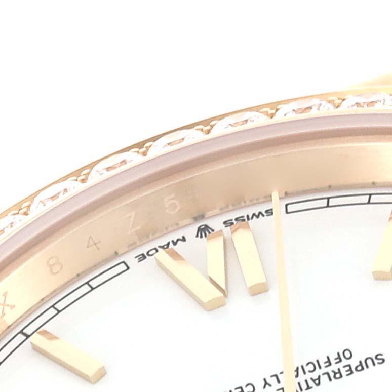 This close-up image of the Rolex President 228348 Men
s Yellow Gold White Dial 228348 Men
s Yellow Gold White Dial watch shows the bezel, part of the dial, and hour markers.
