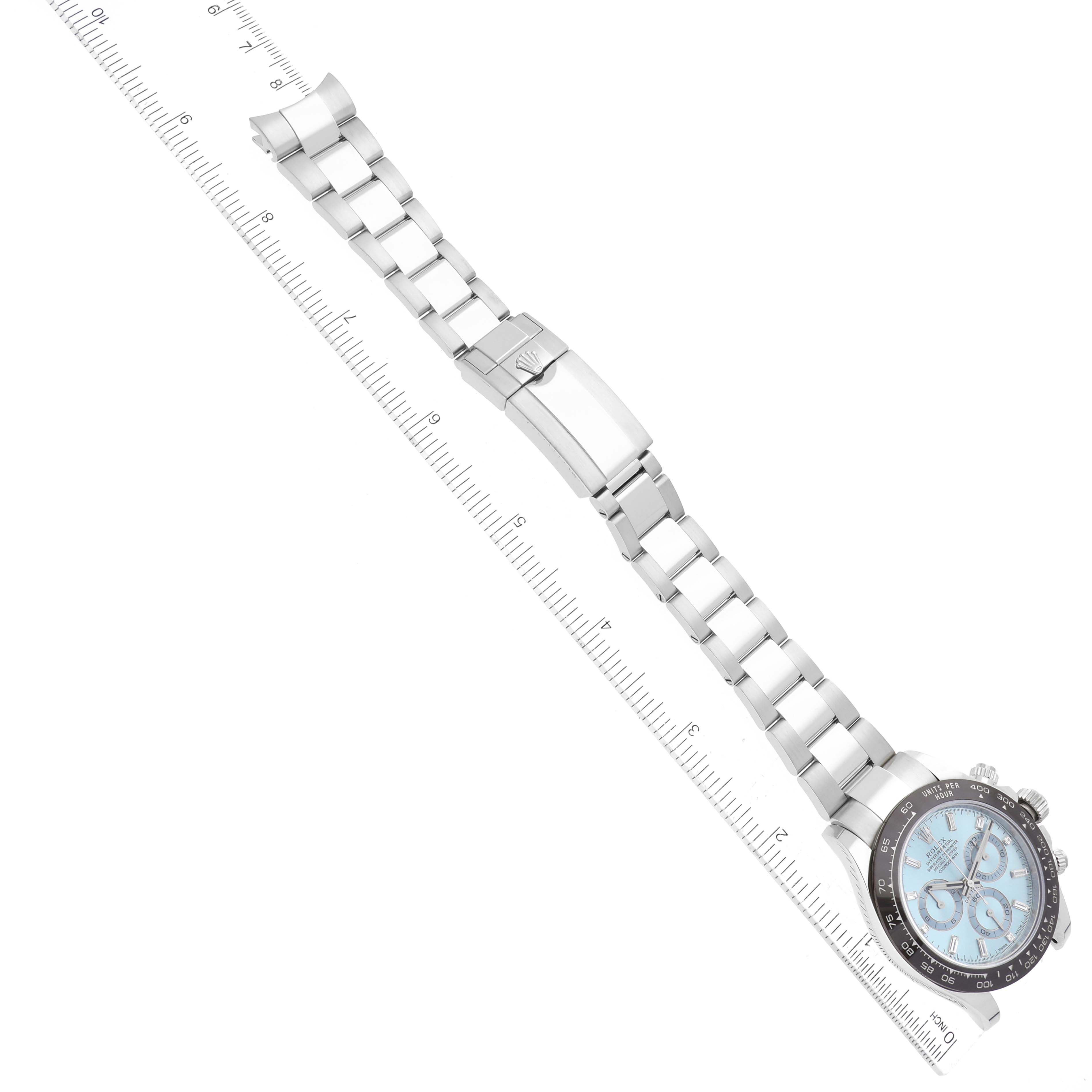 The image shows a top-down view of a Rolex Daytona 116506 Men's Platinum Blue Dial 116506 Men's Platinum Blue Dial watch, highlighting its face and bracelet with a ruler for scale.