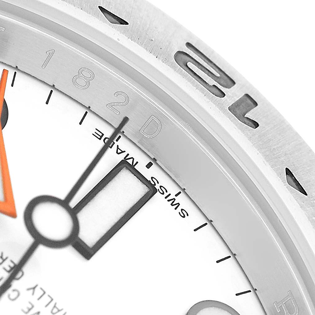 The image shows a close-up of a Rolex Explorer 216570 Men's Stainless Steel White Dial watch, highlighting the bezel, part of the dial, and hands.