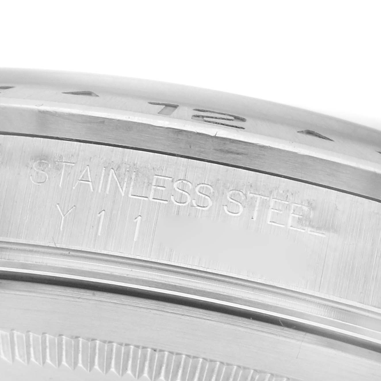 The image shows a close-up of the side of a Rolex Explorer 16570 Men's Stainless Steel Black Dial 16570 Men's Stainless Steel Black Dial watch case with engraved details, including "STAINLESS STEEL".
