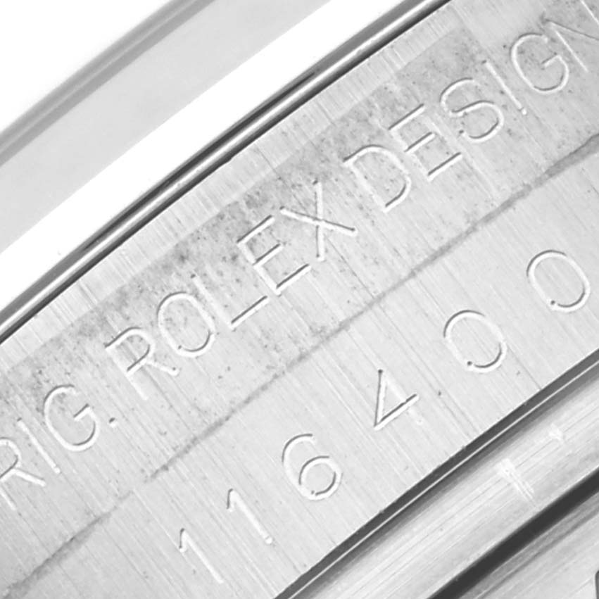 The image shows a close-up of the engraved serial number and "ORIG. ROLEX DESIGN" on the side of the Rolex Milgauss 116400 Men's Stainless Steel White Dial 116400 Men's Stainless Steel White Dial watch casing.