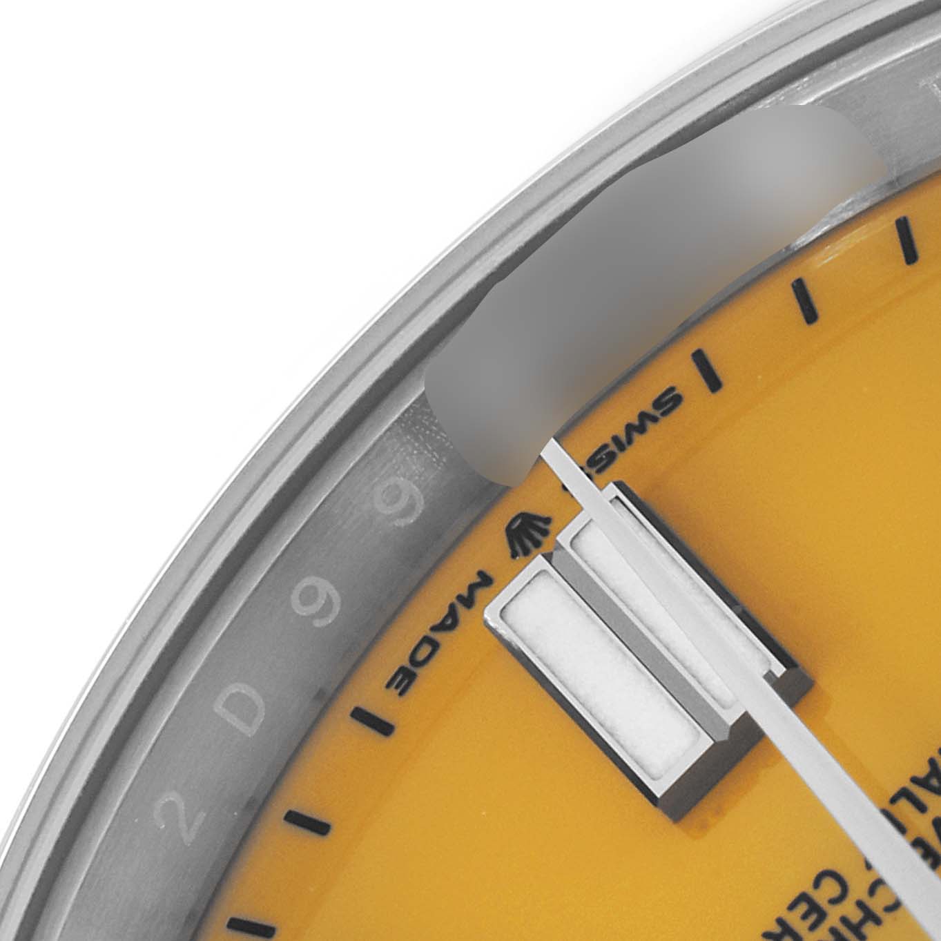 The image shows a partial close-up of the dial and bezel of a Rolex Oyster Perpetual 124300 Men's Stainless Steel Yellow Dial 124300 Men's Stainless Steel Yellow Dial watch.