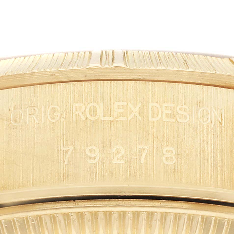 The image shows a close-up of the case side of a Rolex President 79278 Women's Yellow Gold Champagne Dial 79278 Women's Yellow Gold Champagne Dial model, revealing the engraving and part of the bezel.