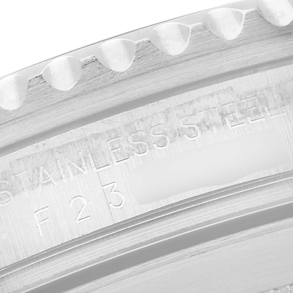 The image shows the edge of the bezel and the engraved inner ring of a Rolex Submariner 16610 Men's Stainless Steel Black Dial, highlighting part of the text.