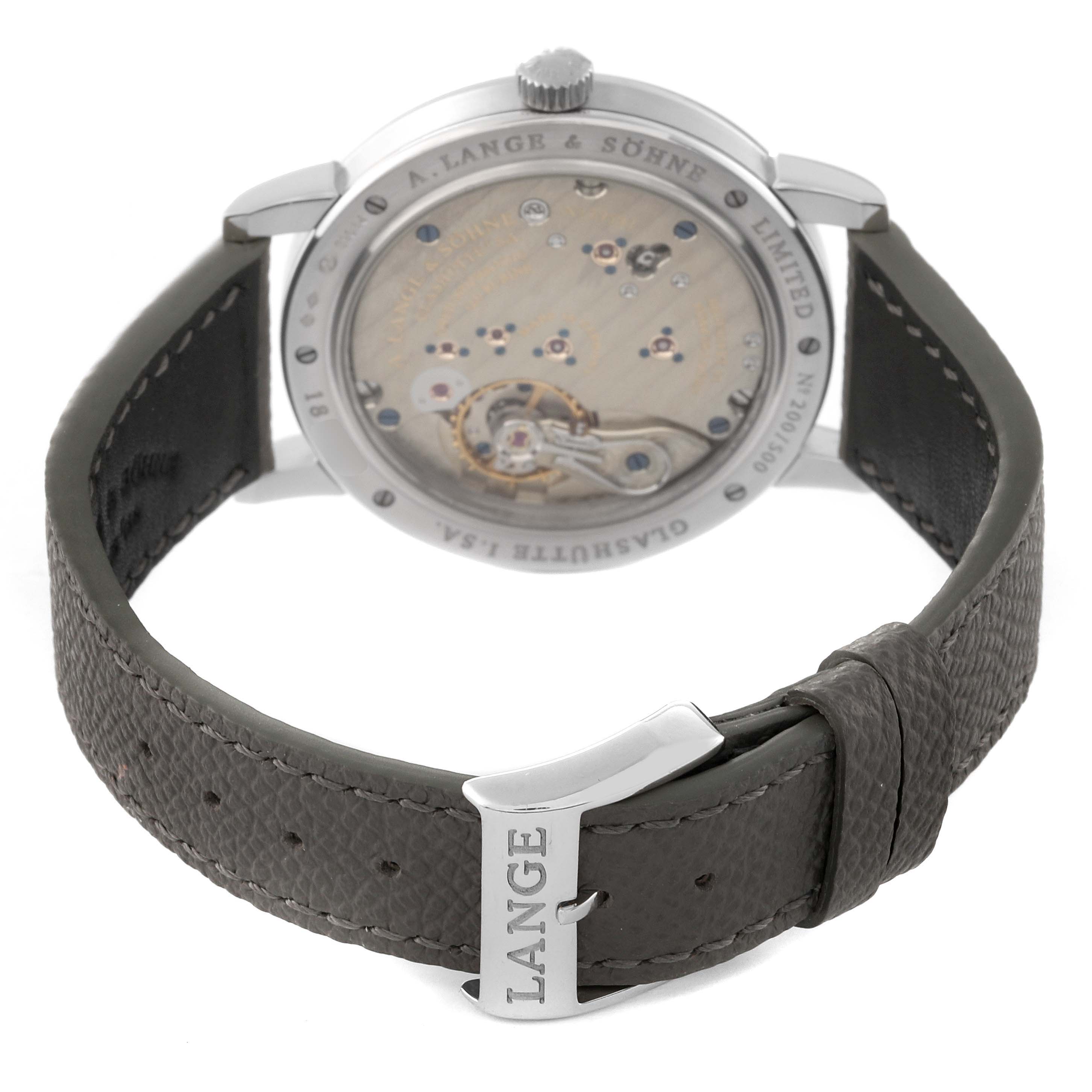 The image shows the back view of an A. Lange & Sohne 1815 233.025 Men's Platinum Silver Dial watch with its movement and part of the strap with "LANGE" inscribed on the buckle.