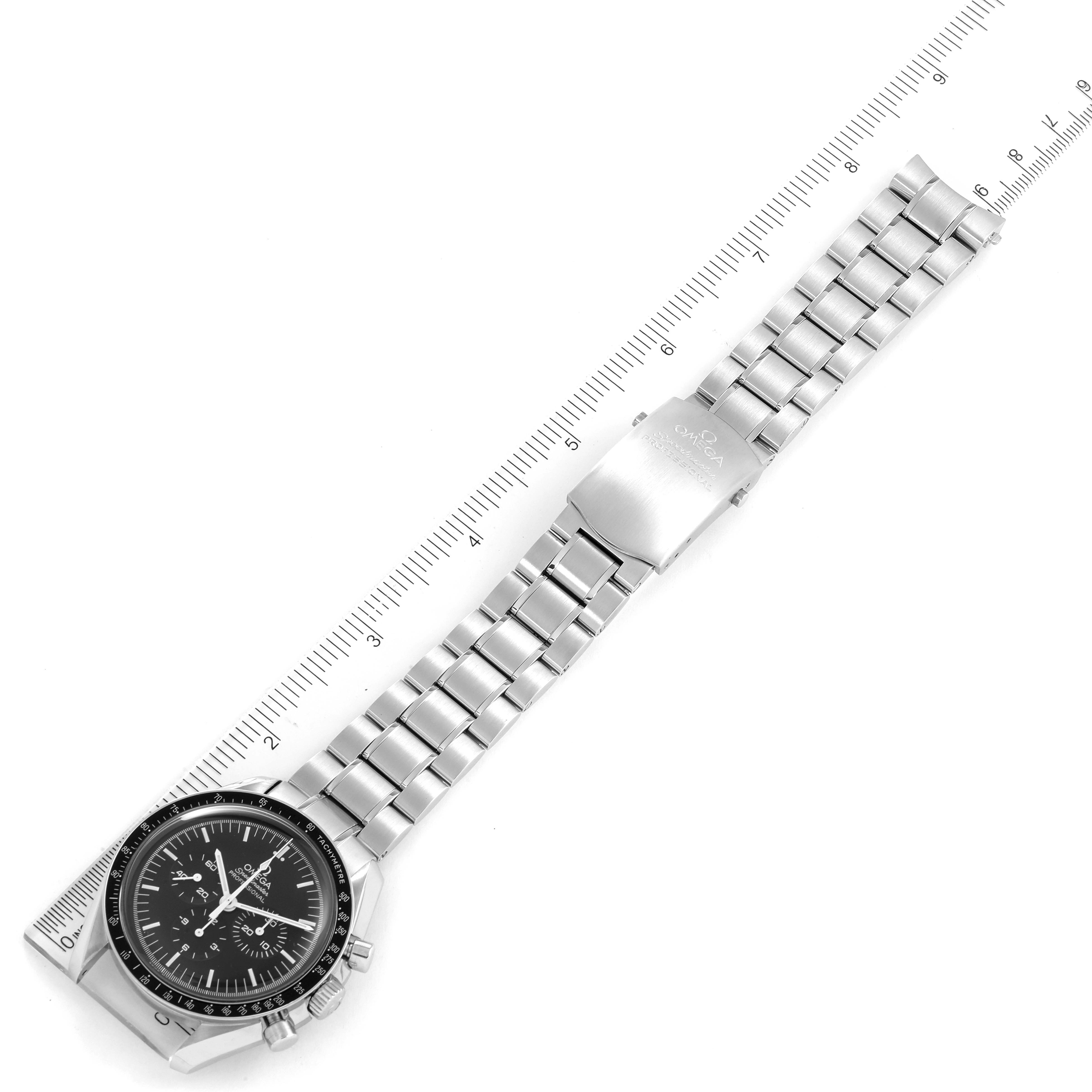 The Omega Speedmaster 311.30.42.30.01.005 Men
s Stainless Steel Black Dial 311.30.42.30.01.005 Men
s Stainless Steel Black Dial watch is shown from a top-down angle, focusing on the face, bracelet, and clasp alongside a ruler.