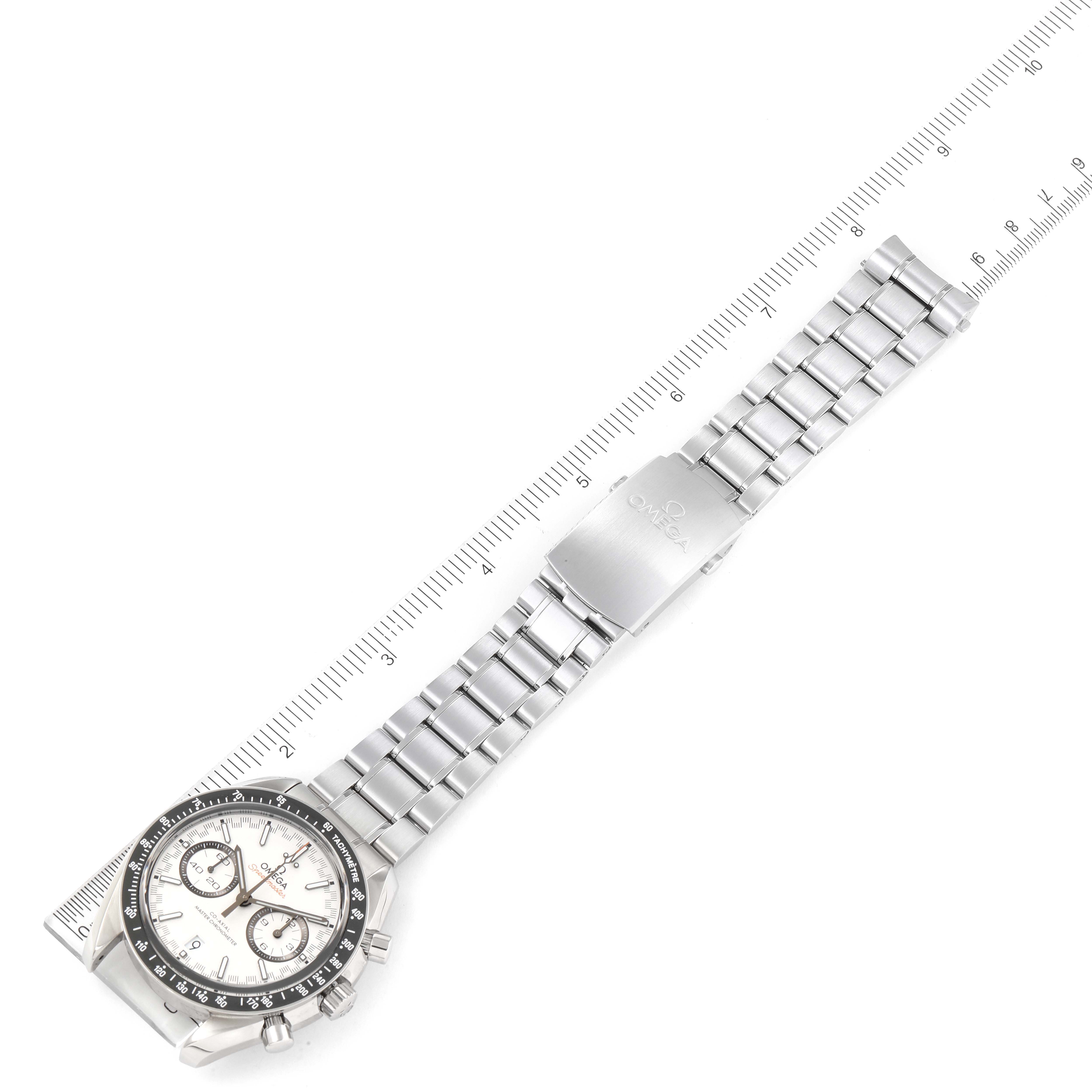 The image shows the Omega Speedmaster 329.30.44.51.04.001 Men's Stainless Steel White Dial 329.30.44.51.04.001 Men's Stainless Steel White Dial watch laid flat with its bracelet extended, alongside a measuring scale.