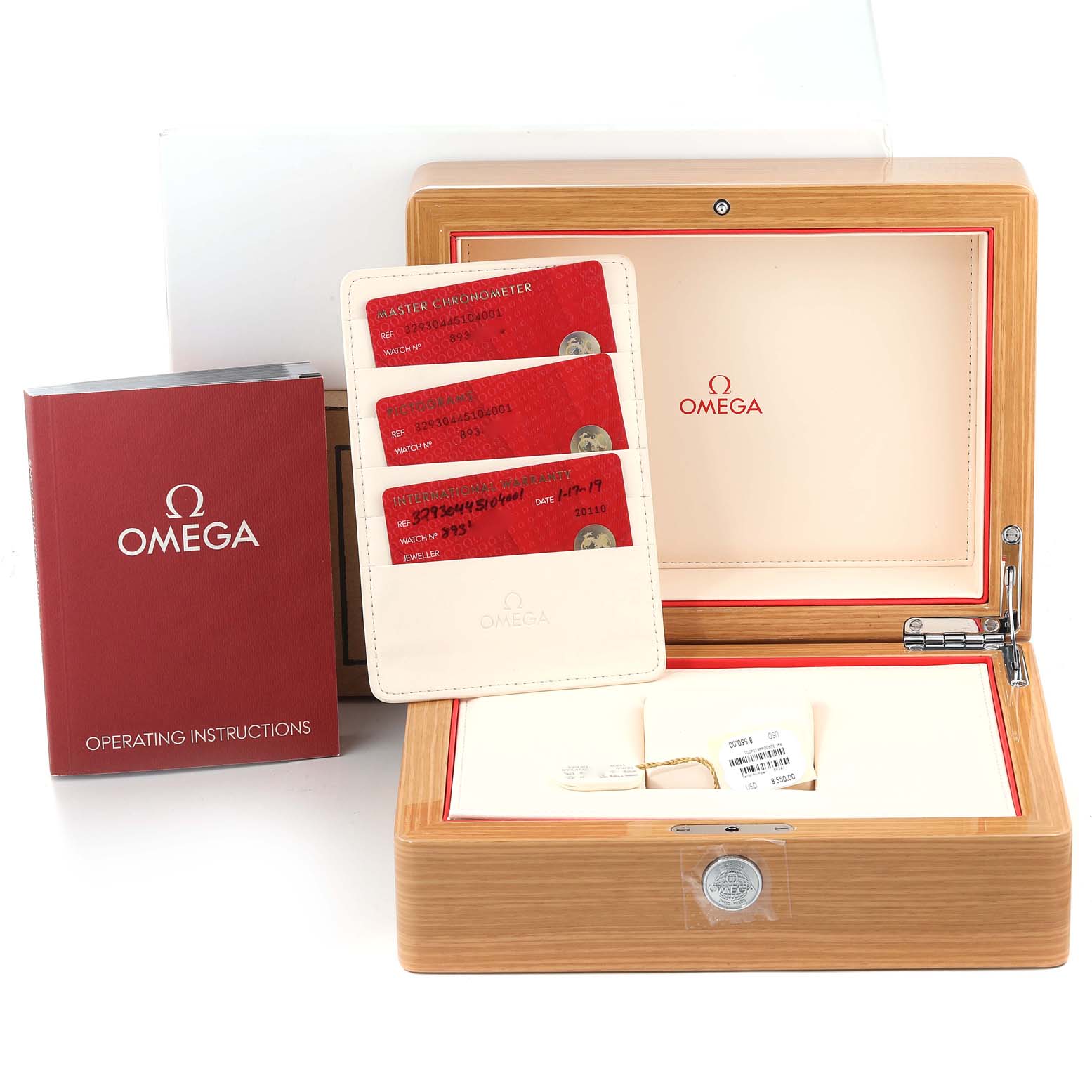 This image shows an Omega Speedmaster 329.30.44.51.04.001 Men's Stainless Steel White Dial 329.30.44.51.04.001 Men's Stainless Steel White Dial watch box, warranty cards, and an operating manual from a frontal view.