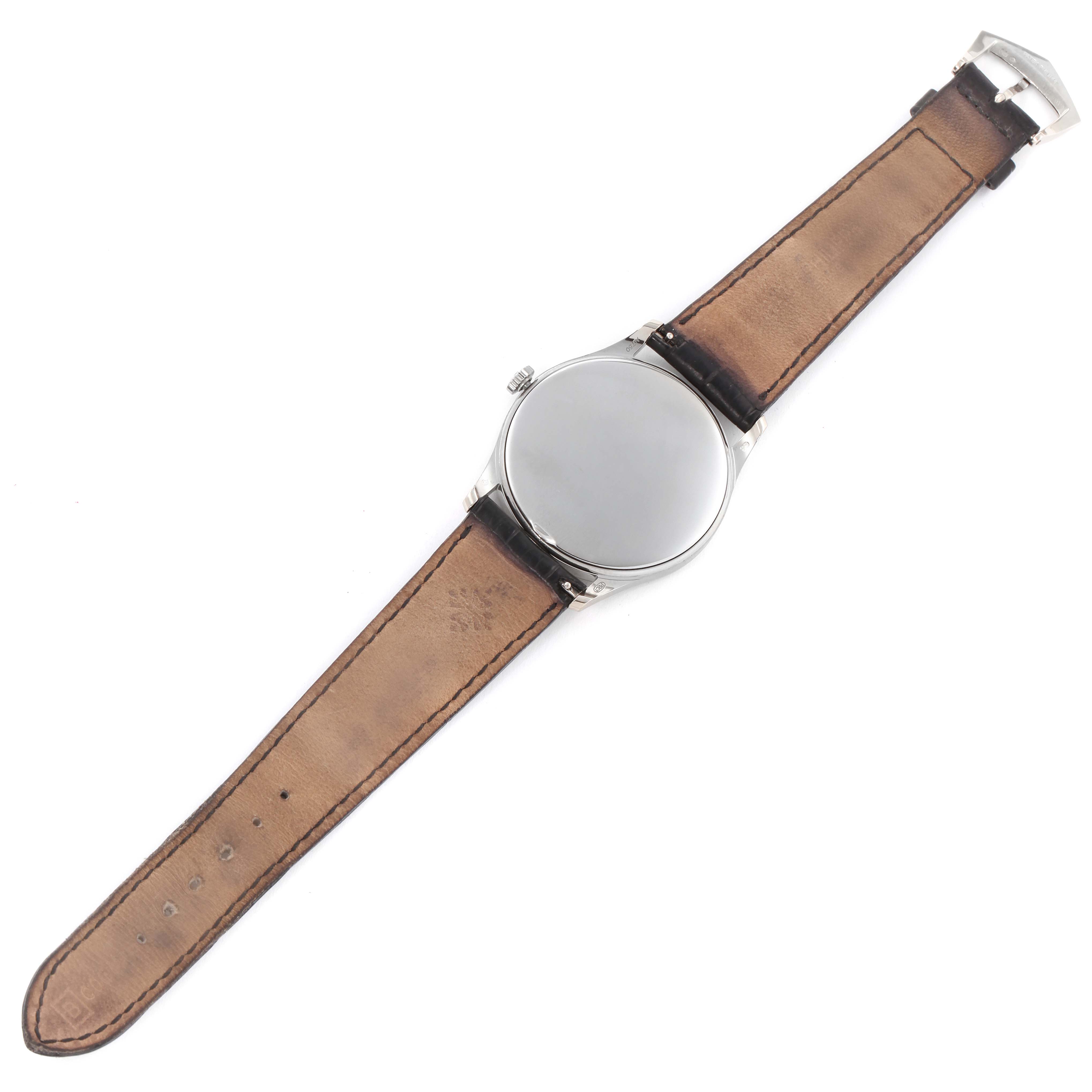 The Calatrava model by Patek Philippe is shown from the top view with the face, crown, and leather strap visible.