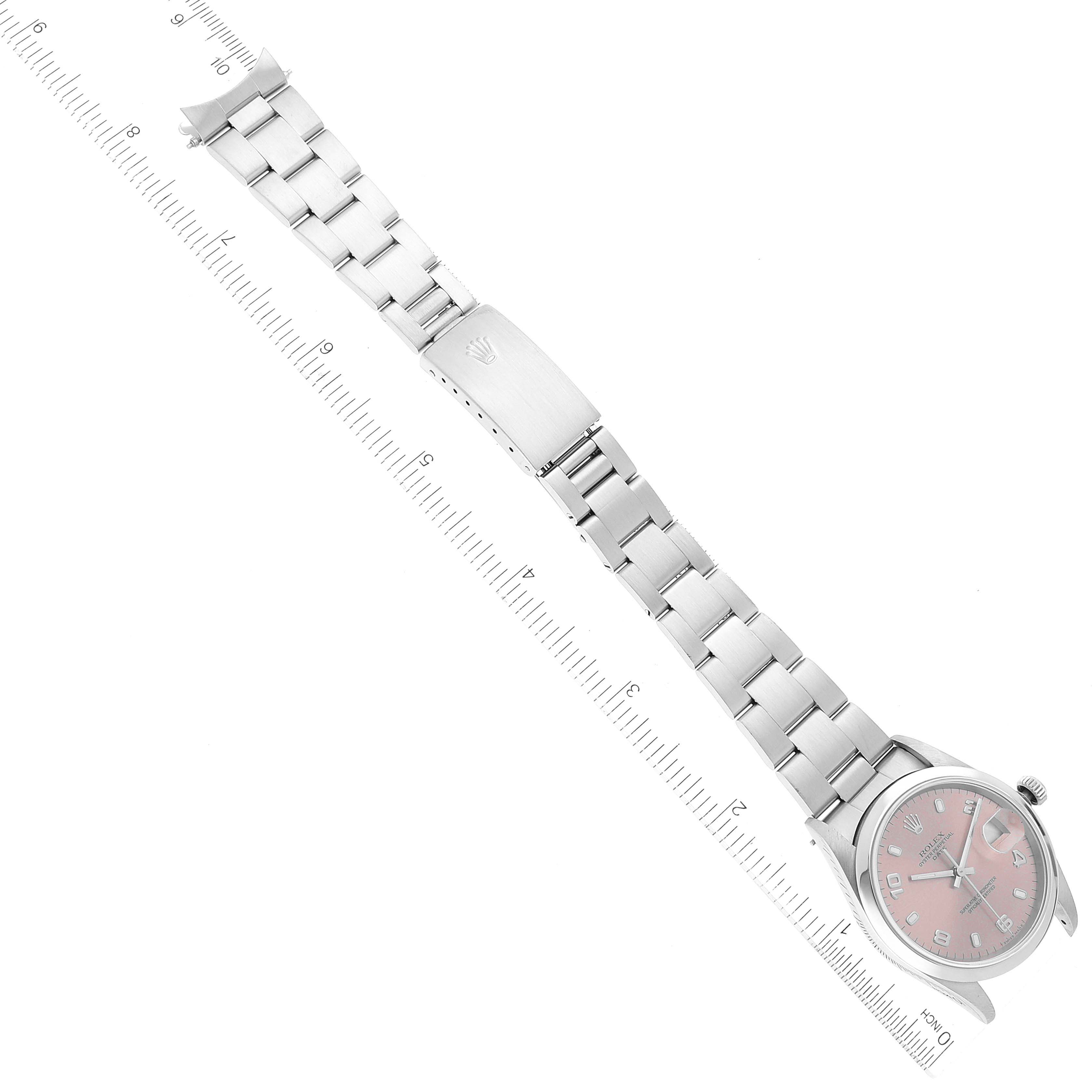 The image shows a Rolex Date 15200 Men's Stainless Steel Pink Dial 15200 Men's Stainless Steel Pink Dial model watch laid flat with the dial, bracelet, and clasp visible, alongside a measurement ruler.
