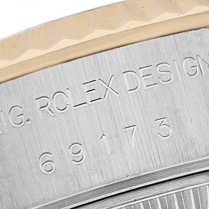 This close-up image shows part of the case engraving and bezel detail of a Rolex Datejust 69173 Women's Steel and Gold (two tone) Grey Dial 69173 Women's Steel and Gold (two tone) Grey Dial watch.