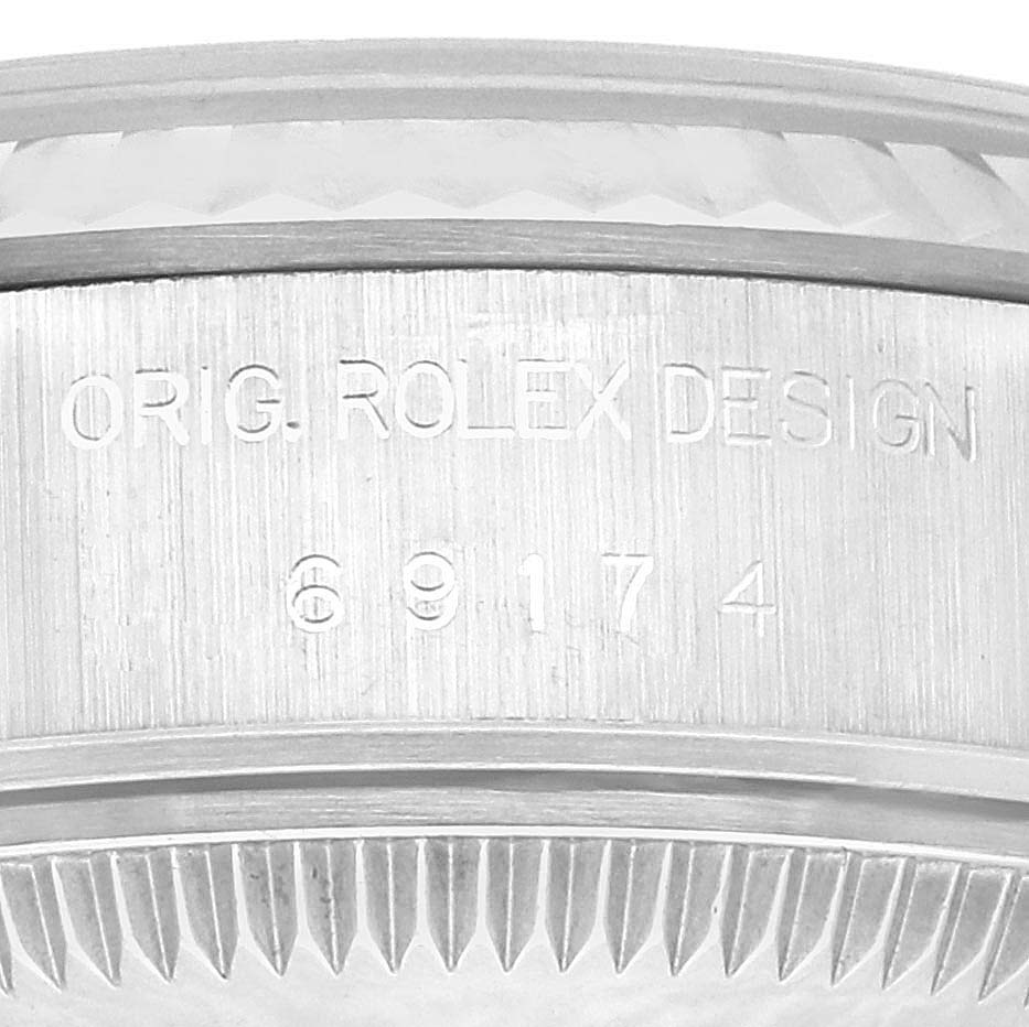 Close-up view of the side of a Rolex Datejust 69174 Women's Stainless Steel Silver Dial 69174 Women's Stainless Steel Silver Dial watch, showing the engraved model number and "ORIG. ROLEX DESIGN."