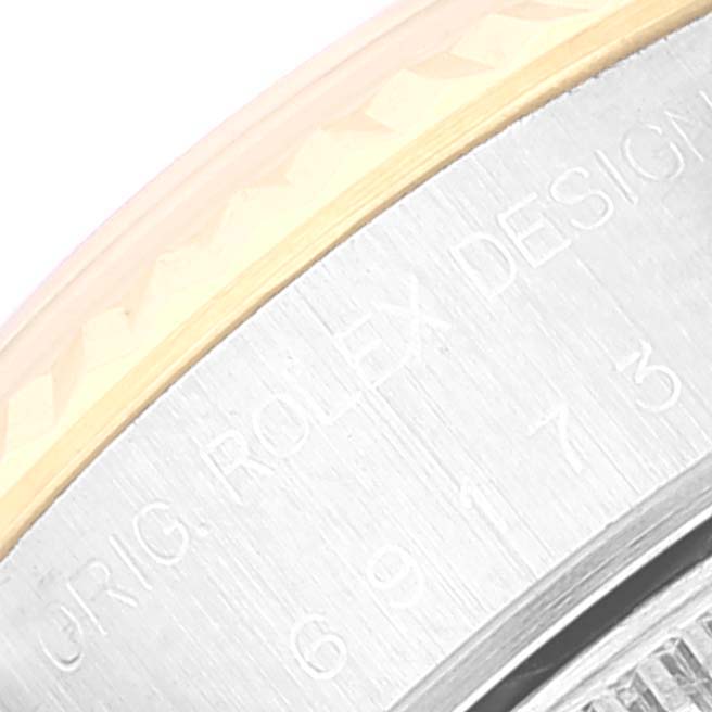 The image shows a close-up of the edge and side of a Rolex Datejust 69173 Women's Steel and Gold (two tone) Champagne Dial 69173 Women's Steel and Gold (two tone) Champagne Dial watch, focusing on the engraved text and bezel.