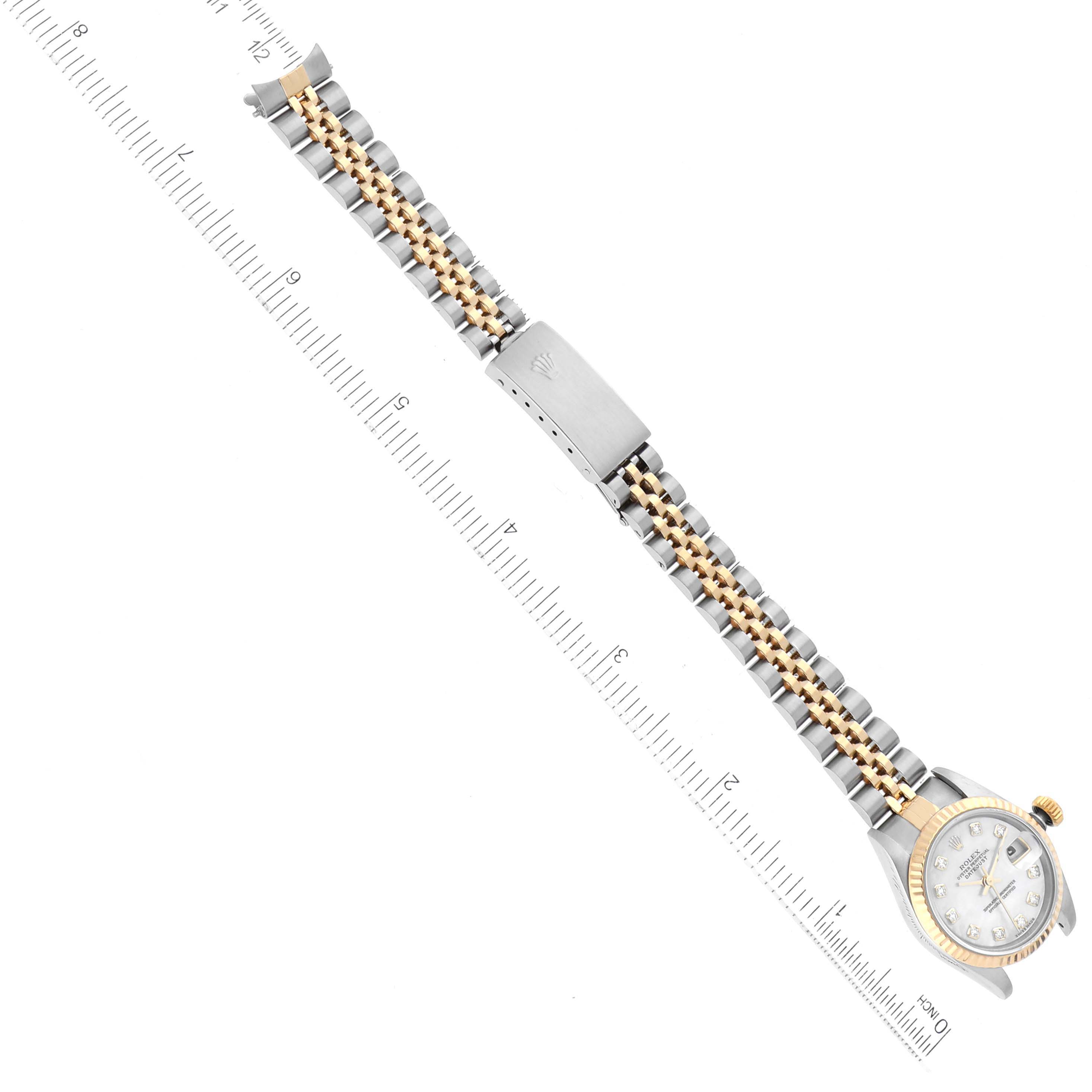 The image shows a Rolex Datejust 79173 Women's Stainless Steel Mother of Pearl Dial 79173 Women's Stainless Steel Mother of Pearl Dial watch laid flat with an angled view of its band and face alongside a ruler.