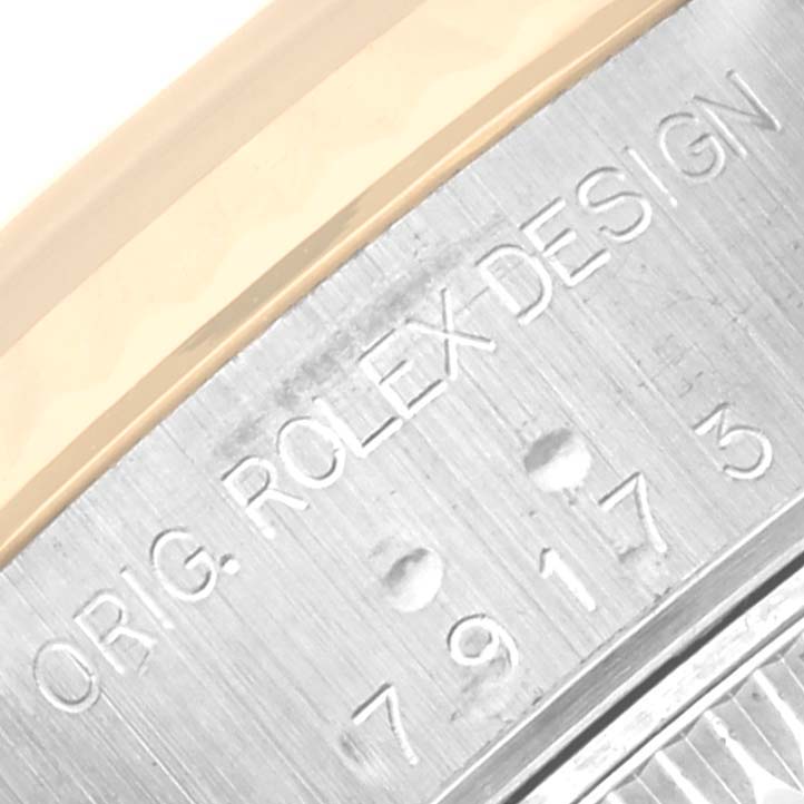This close-up image shows the engraved text "ORIG. ROLEX DESIGN" and a serial number on the side of a Rolex Datejust 79173 Women's Stainless Steel Mother of Pearl Dial 79173 Women's Stainless Steel Mother of Pearl Dial watch case.