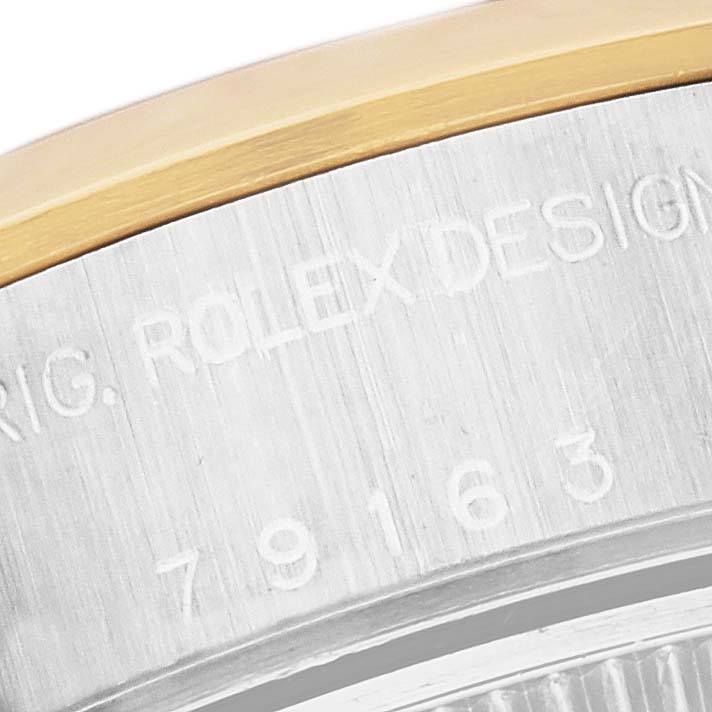 This close-up image shows part of the Rolex Datejust 79163 Women's Steel and Gold (two tone) White Dial 79163 Women's Steel and Gold (two tone) White Dial watch case with engraving details.