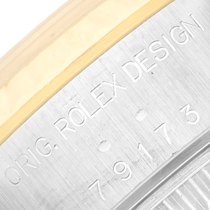 This image shows a close-up of the engraved bezel of a Rolex Datejust 79173 Women's Steel and Gold (two tone) White Dial 79173 Women's Steel and Gold (two tone) White Dial watch.