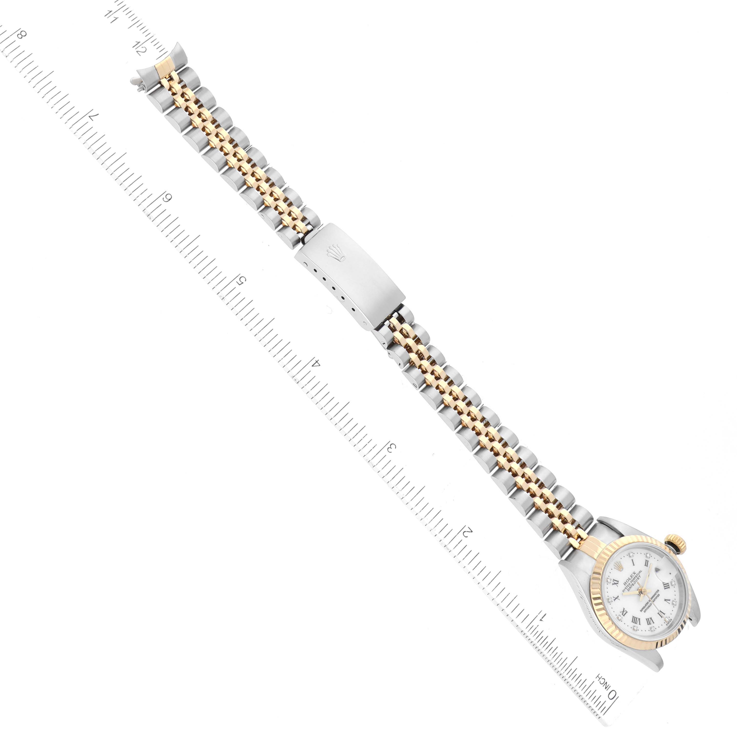 The Rolex Datejust 79173 Women's Steel and Gold (two tone) White Dial 79173 Women's Steel and Gold (two tone) White Dial watch is shown horizontally with a full view of the watch face and bracelet alongside a ruler for scale.