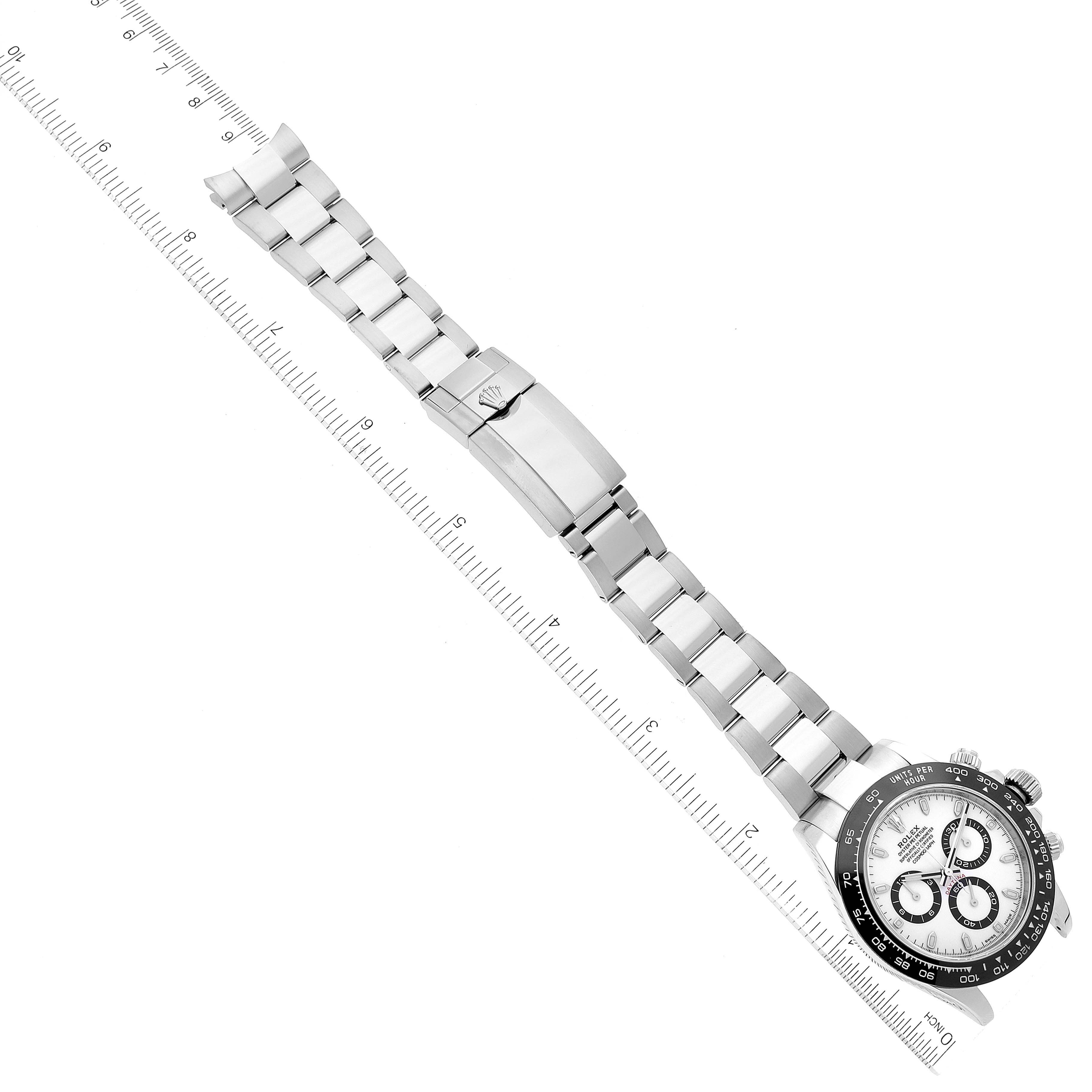 The image shows a full view of the Rolex Daytona 116500 Men
s Stainless Steel White Dial 116500 Men
s Stainless Steel White Dial watch laid flat with a clear view of the band and clasp.