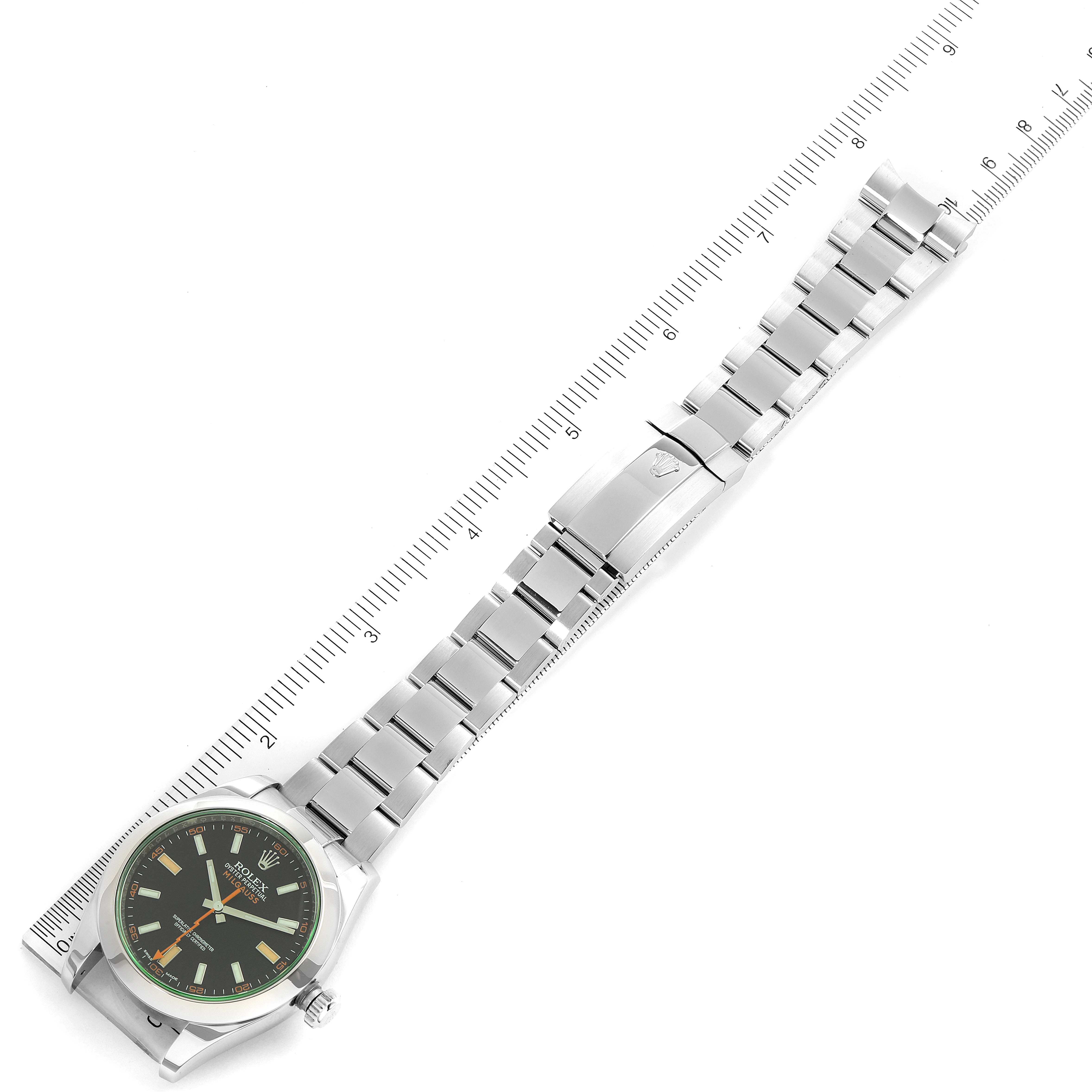 This image shows a top view of a Rolex Milgauss 116400V Men's Stainless Steel Black Dial 116400V Men's Stainless Steel Black Dial watch displaying the face, band, and clasp with a measuring ruler beside it.